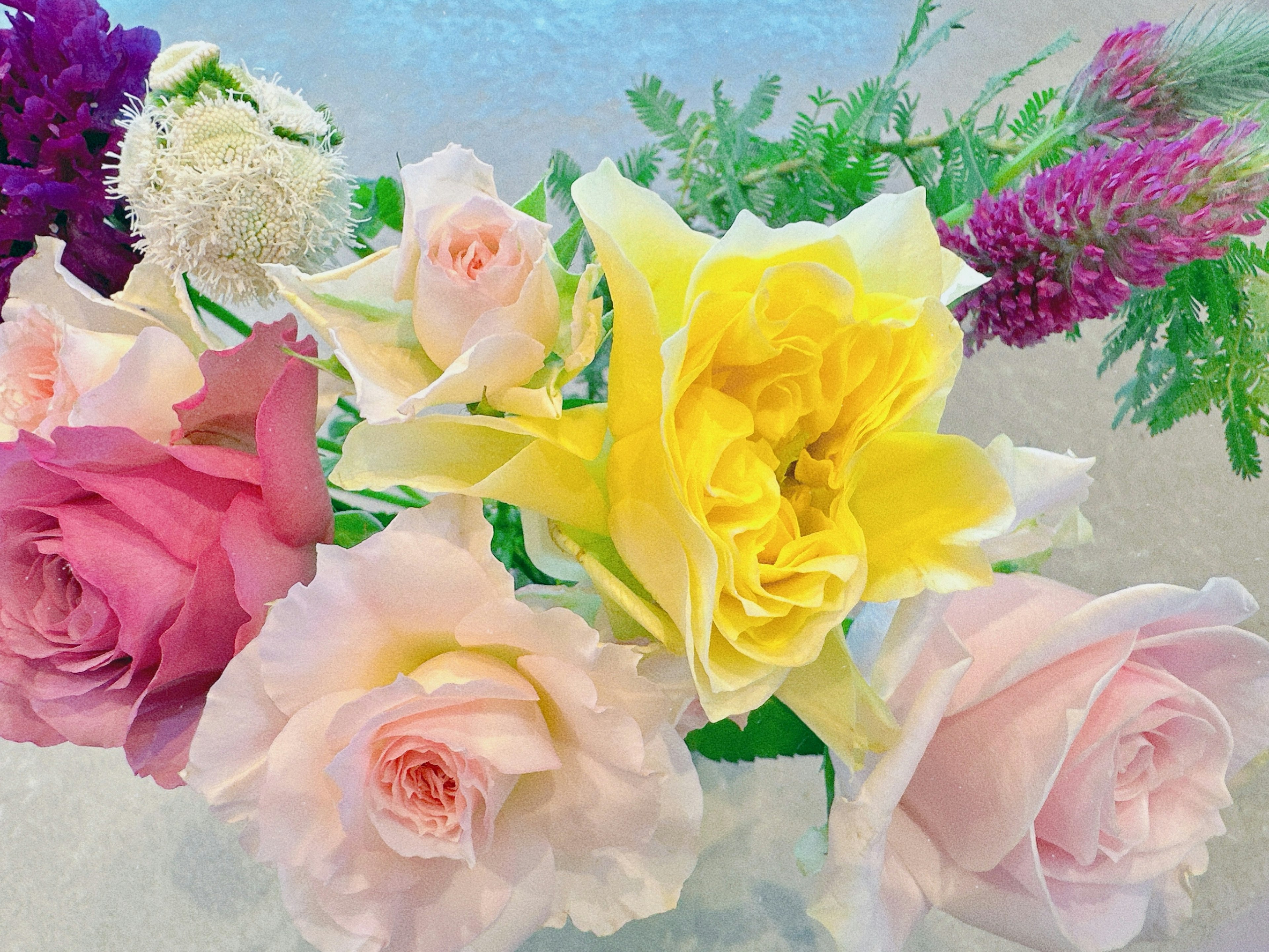 A vibrant bouquet featuring pink and yellow roses among other flowers