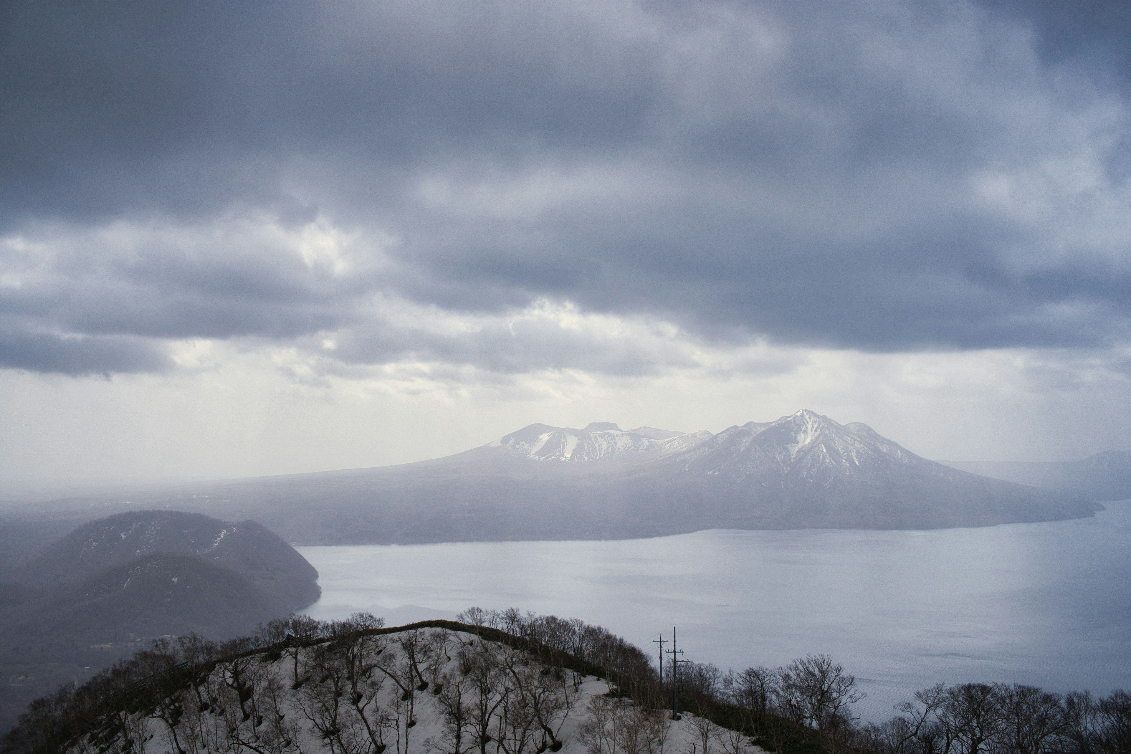 Vista di montagne innevate e lago con cielo nuvoloso