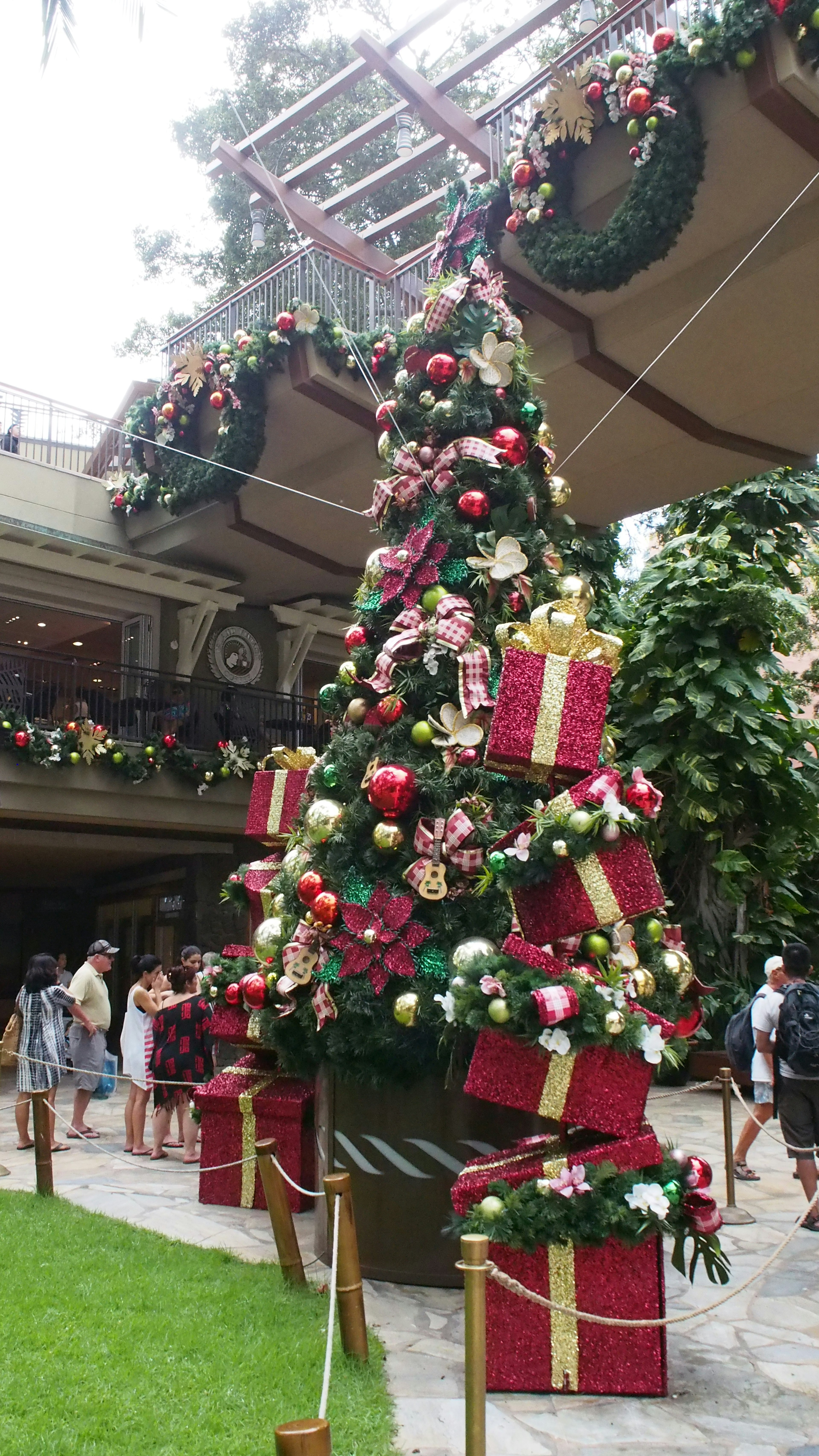 Festively decorated Christmas tree with colorful gifts in a shopping mall