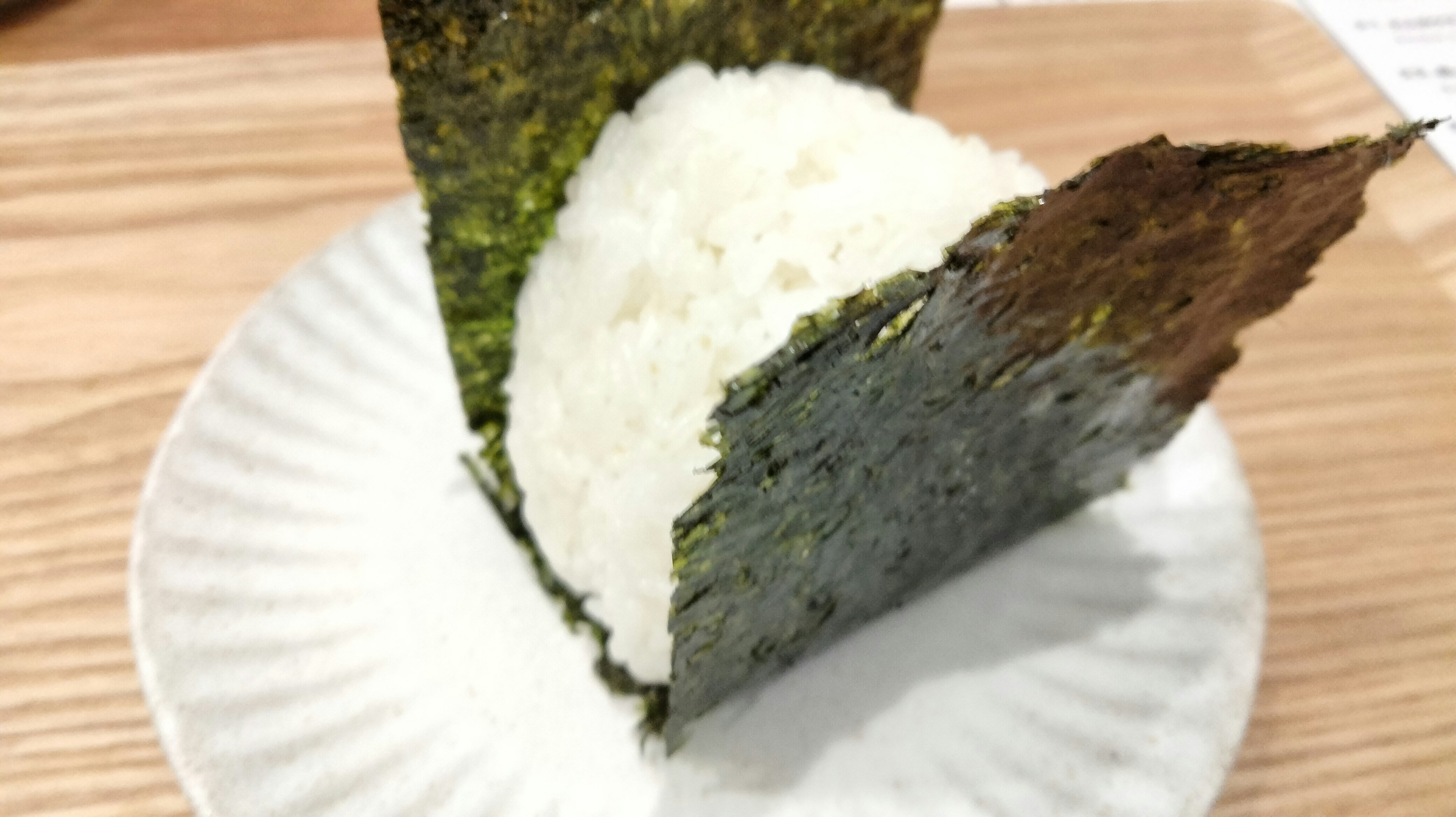 Triangle-shaped rice wrapped in seaweed served on a plate