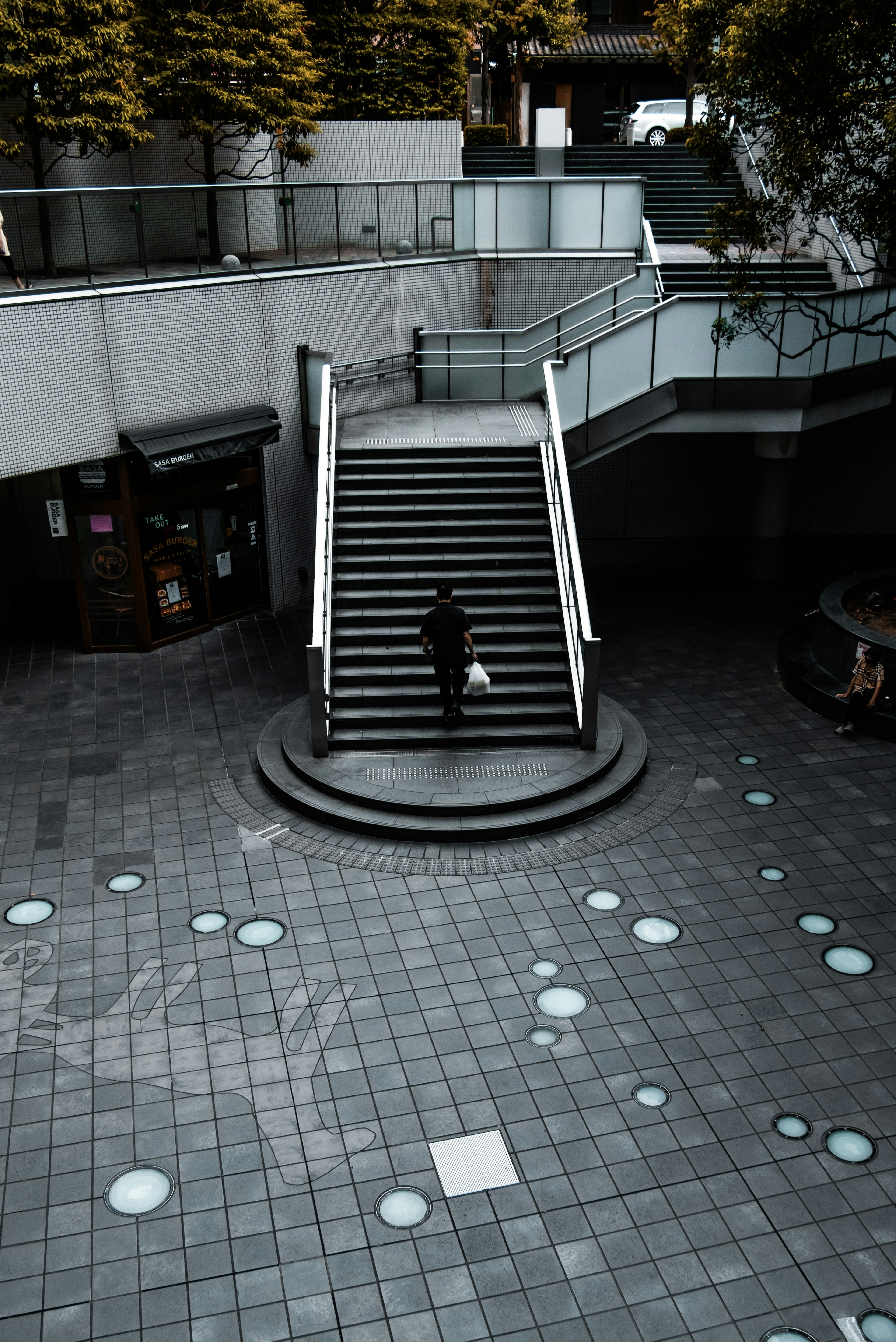 Una persona subiendo escaleras con patrones circulares en el suelo