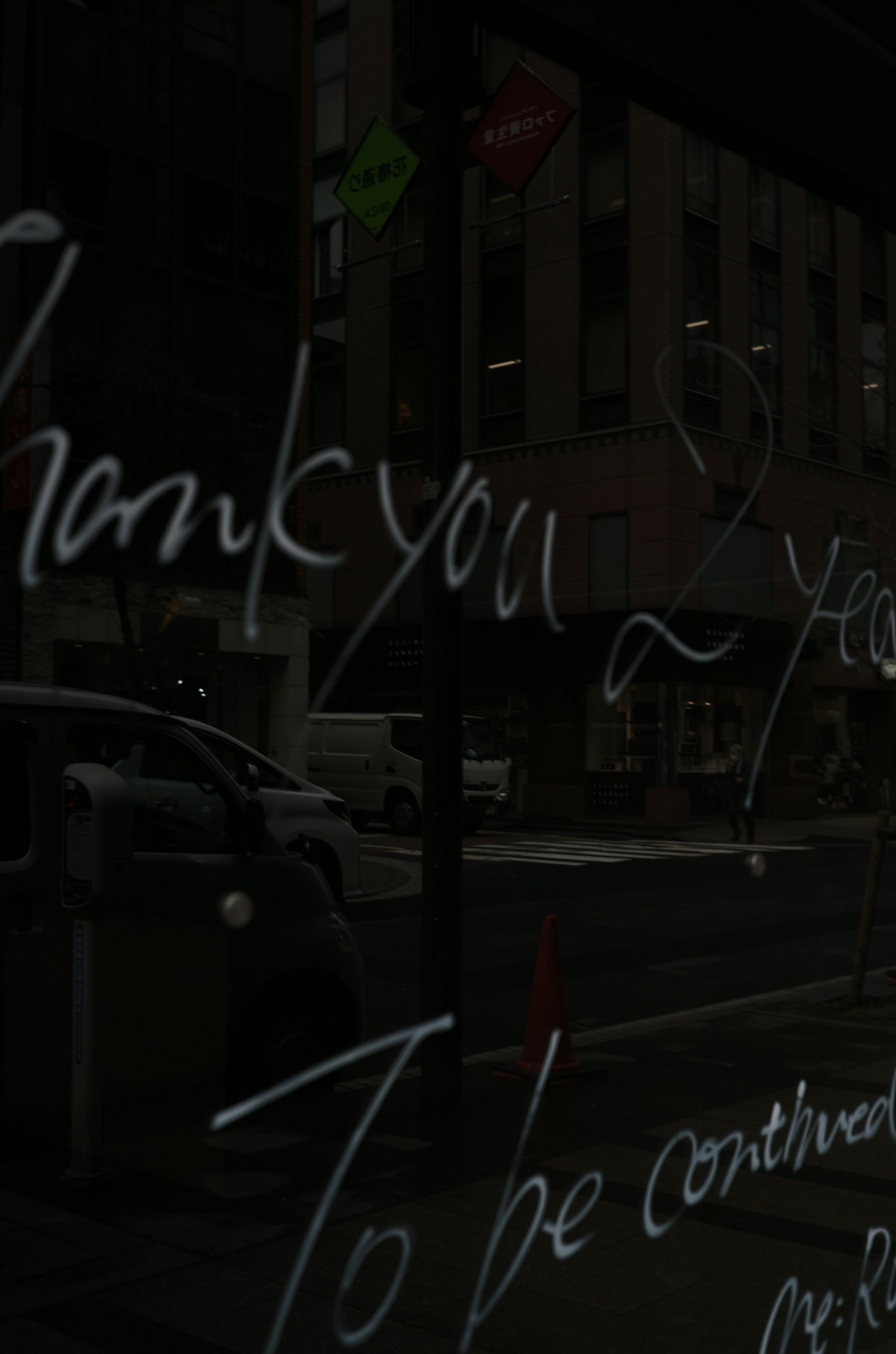 Thank you message written on a glass window with a city backdrop