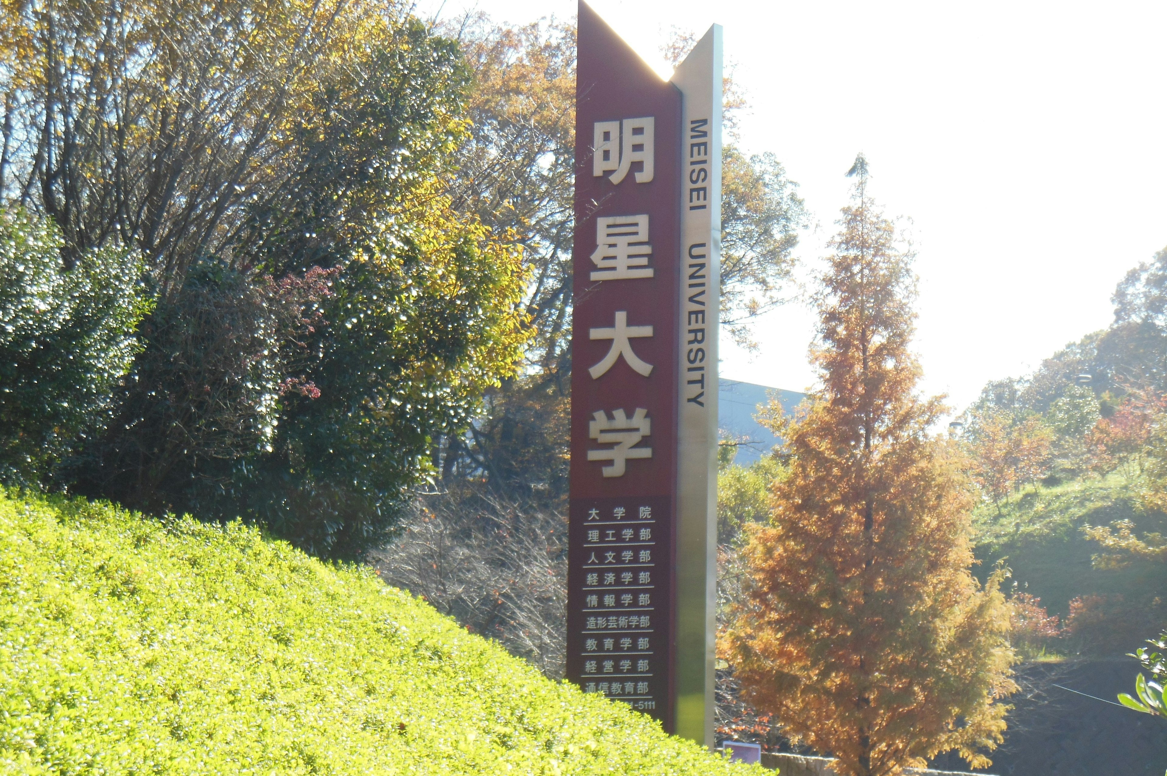 Sign of Meisei University in front of green grass