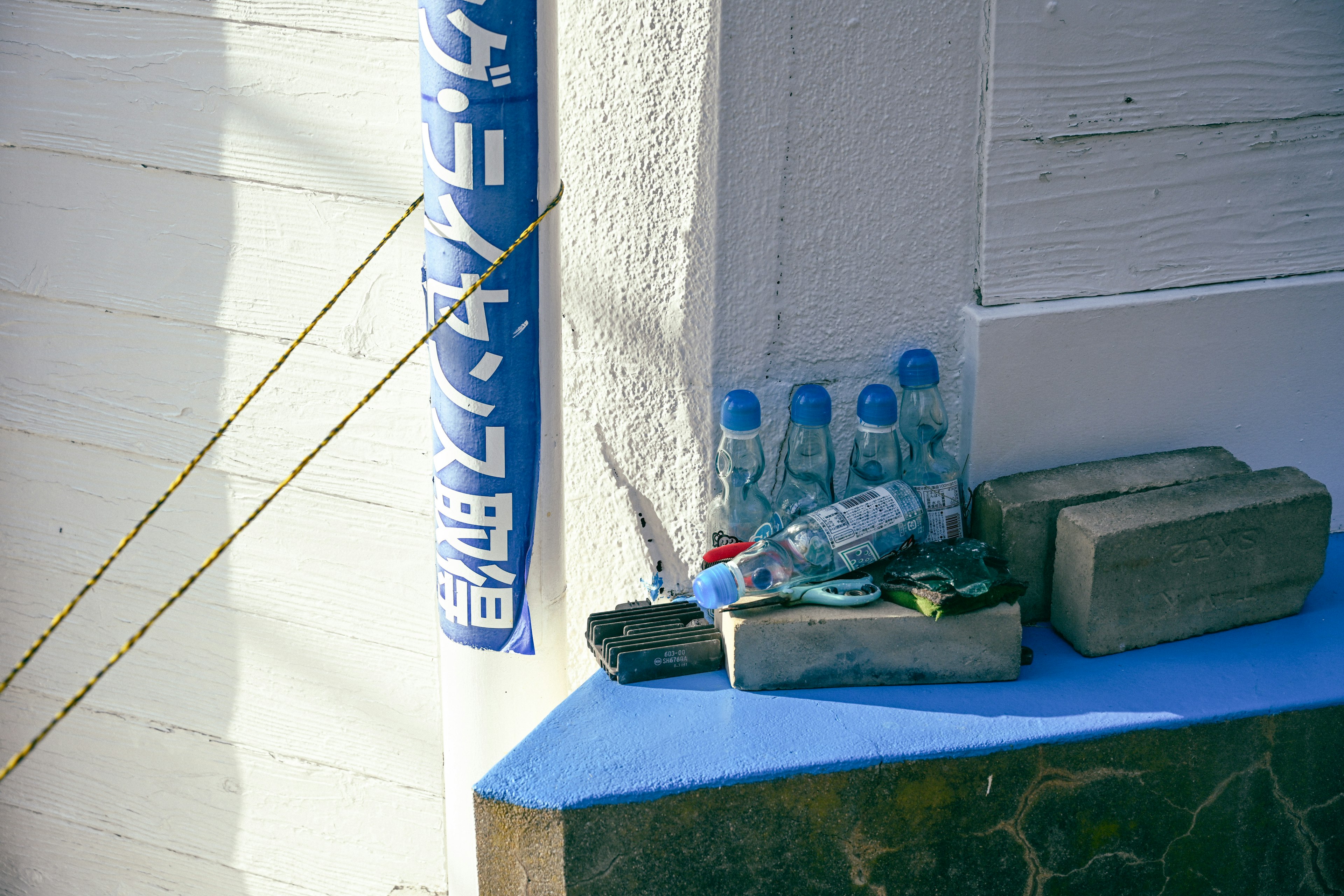 Botol air dan blok kayu di atas meja biru