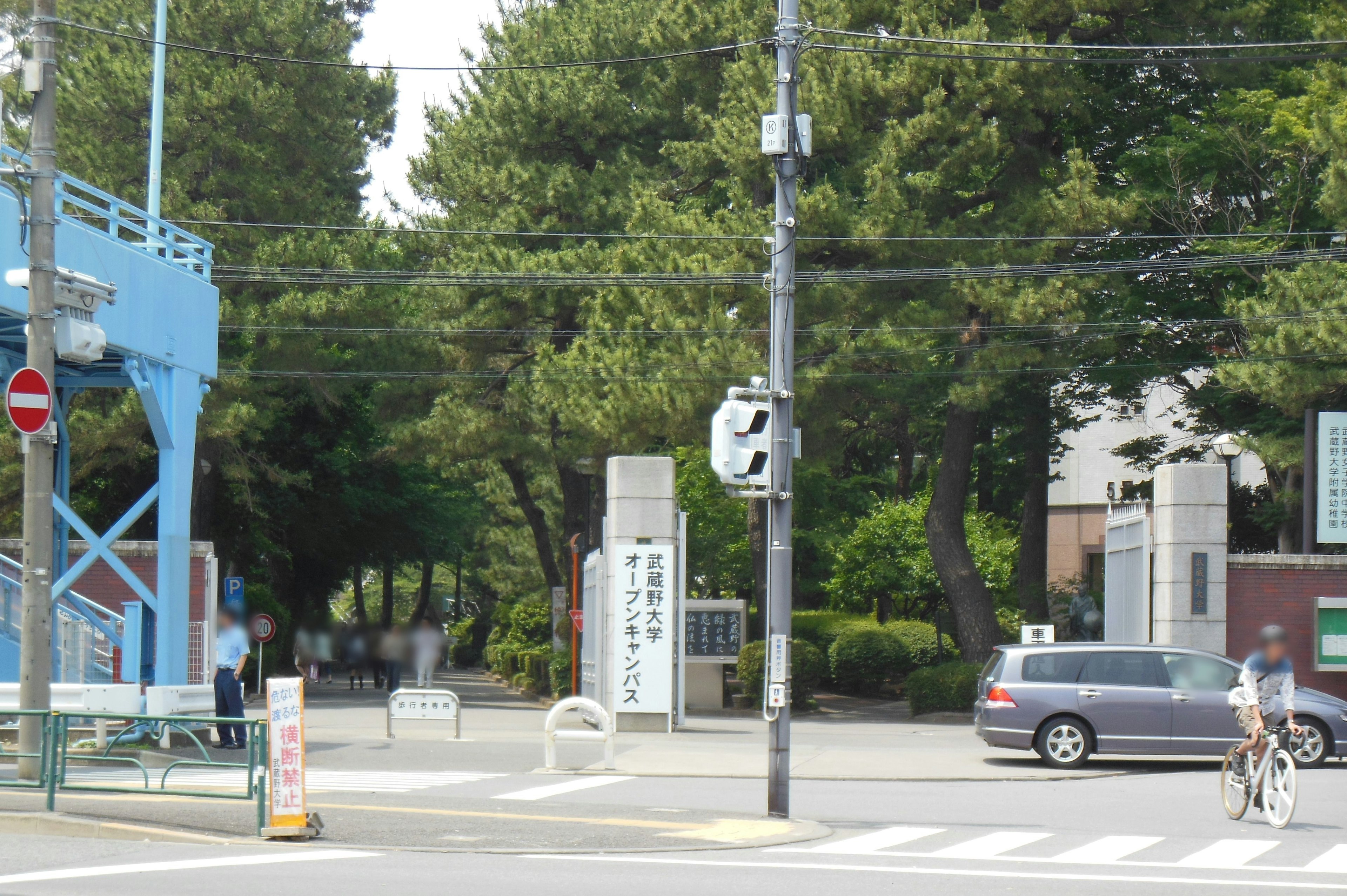 Intersection view featuring a blue bridge and green trees