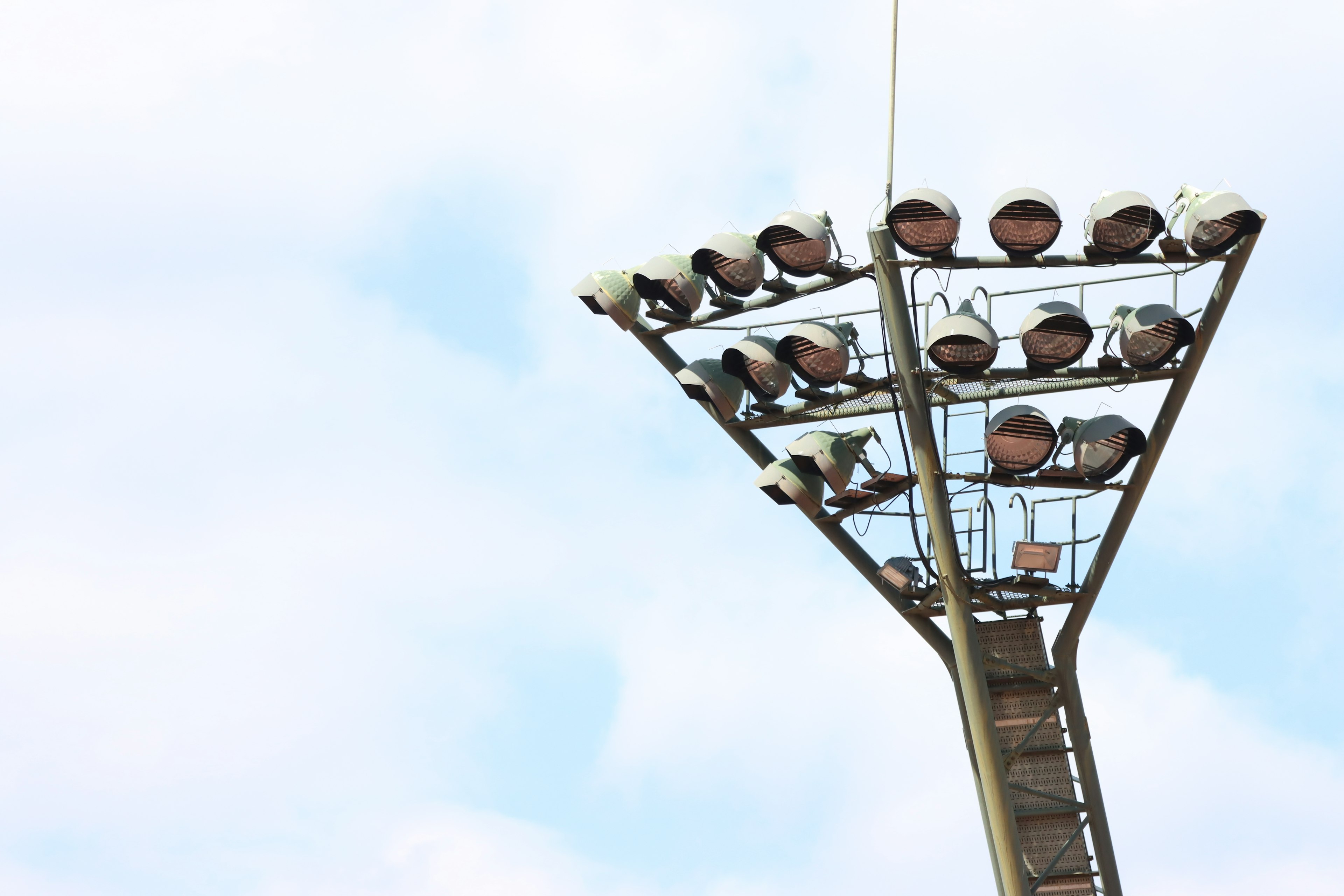 Numerosi apparecchi di illuminazione montati sulla parte superiore di un palo di illuminazione per campi sportivi