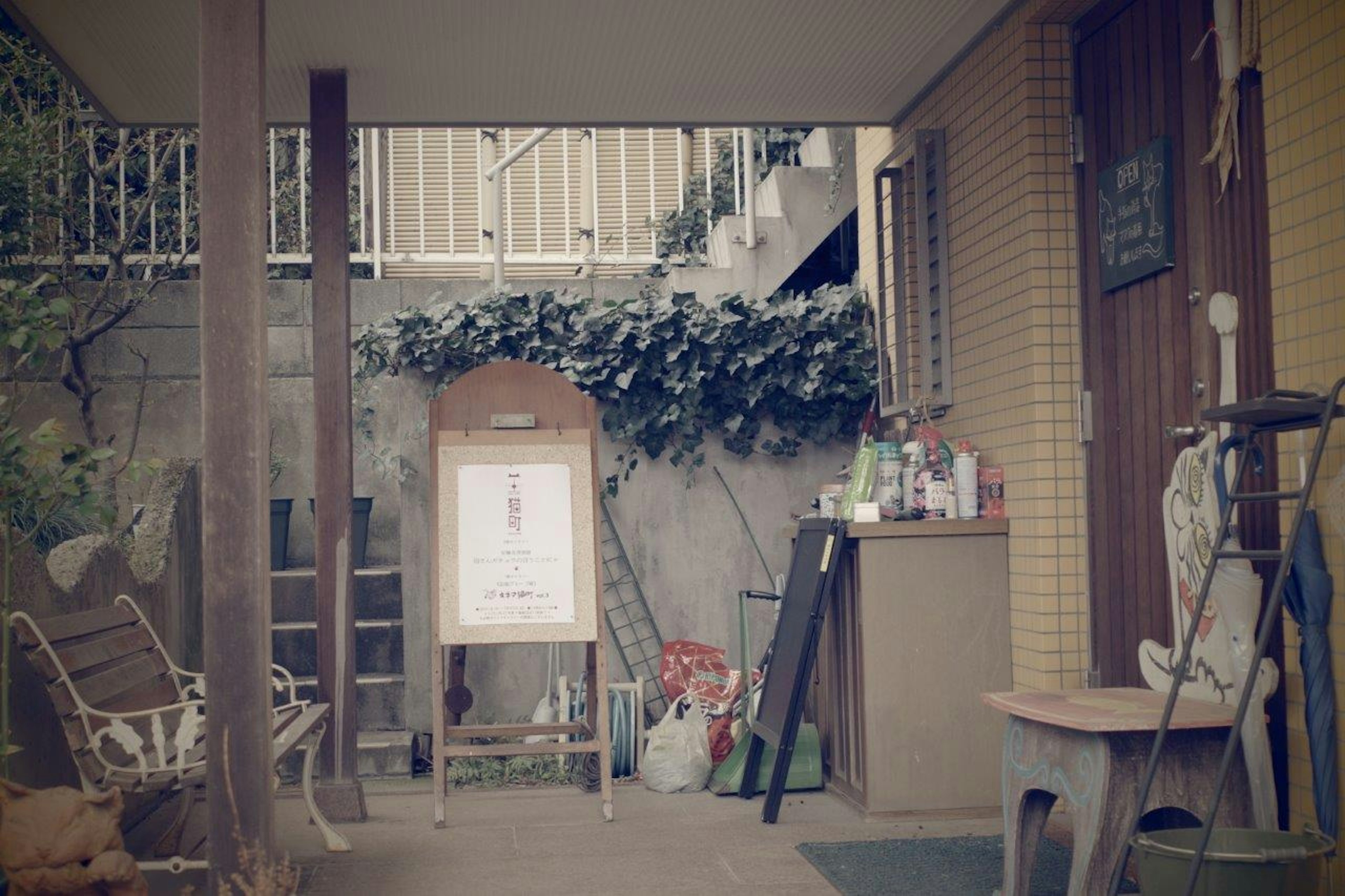 Entrance area featuring a sign board and surrounding plants and furniture