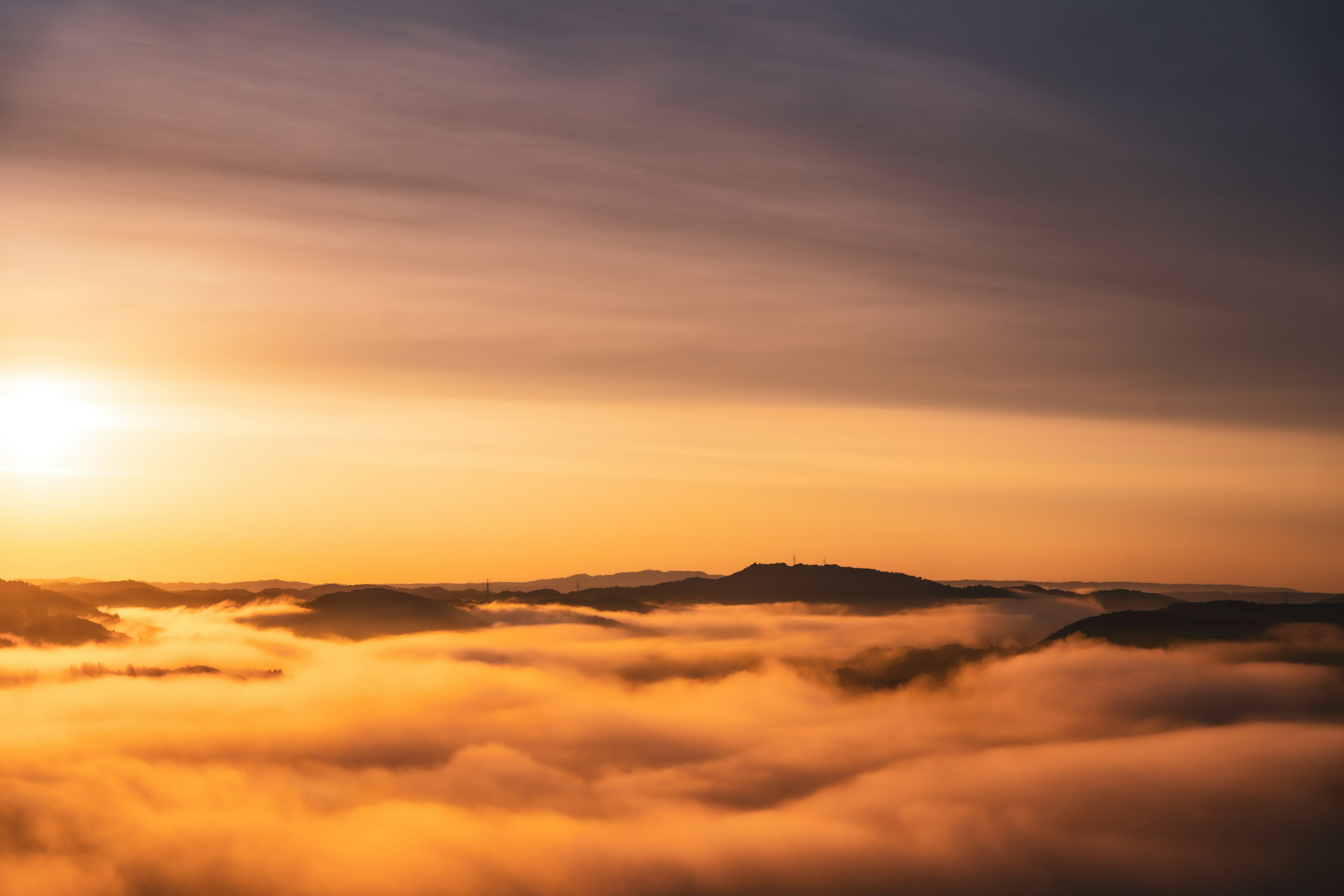 Mountain landscape shrouded in fog with sunrise