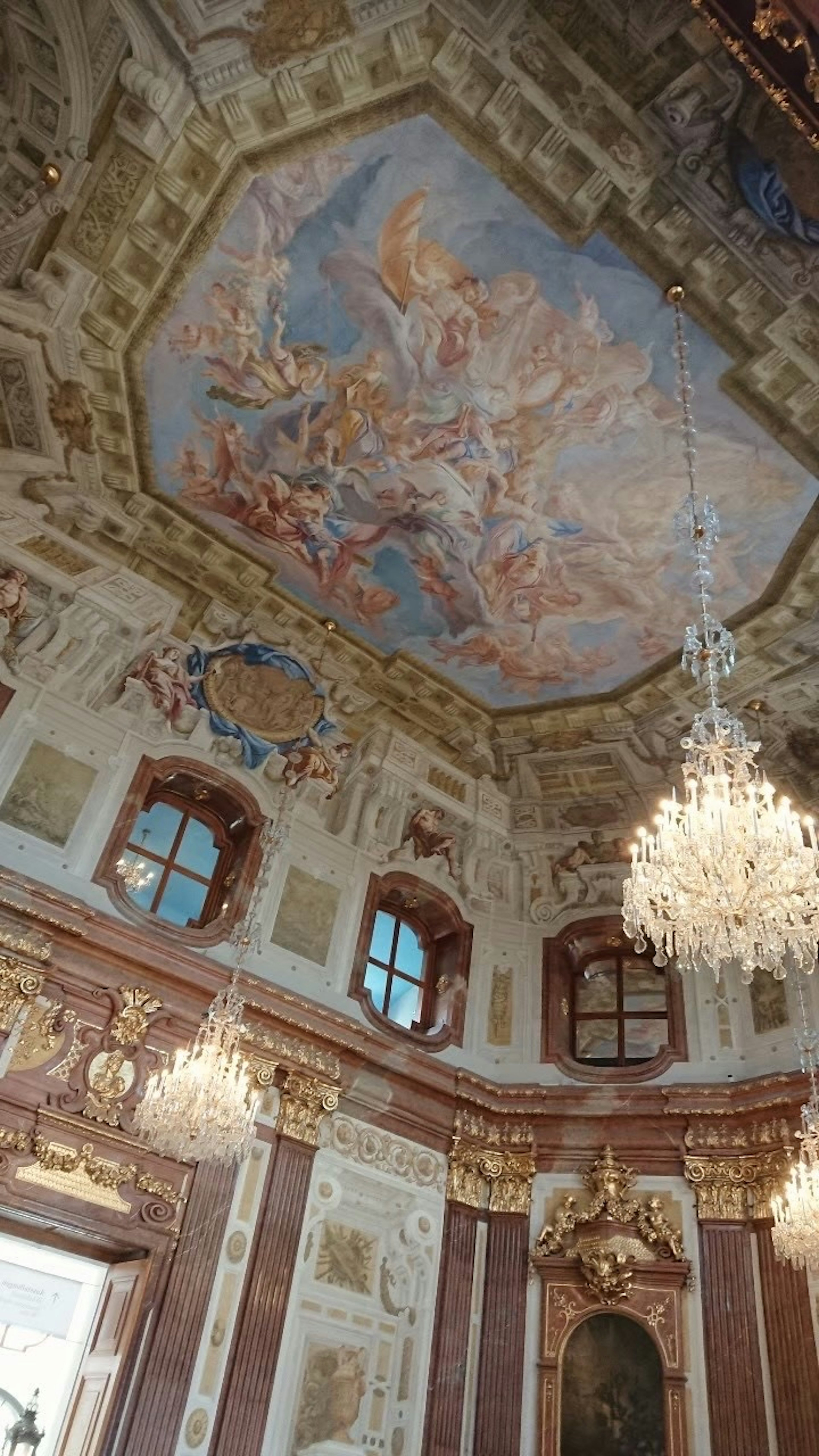 Interior featuring ornate chandeliers and a stunning ceiling fresco