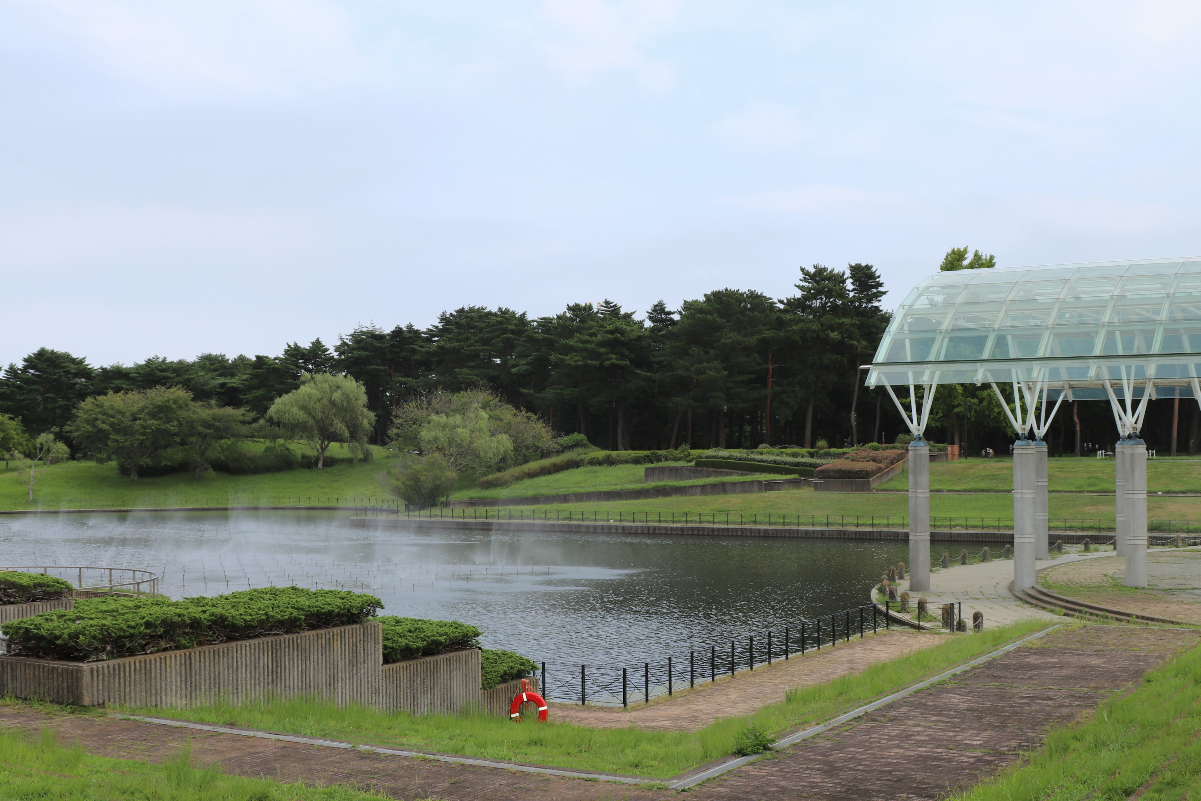 Ruhiger Parksee mit einer modernen Struktur in der Nähe