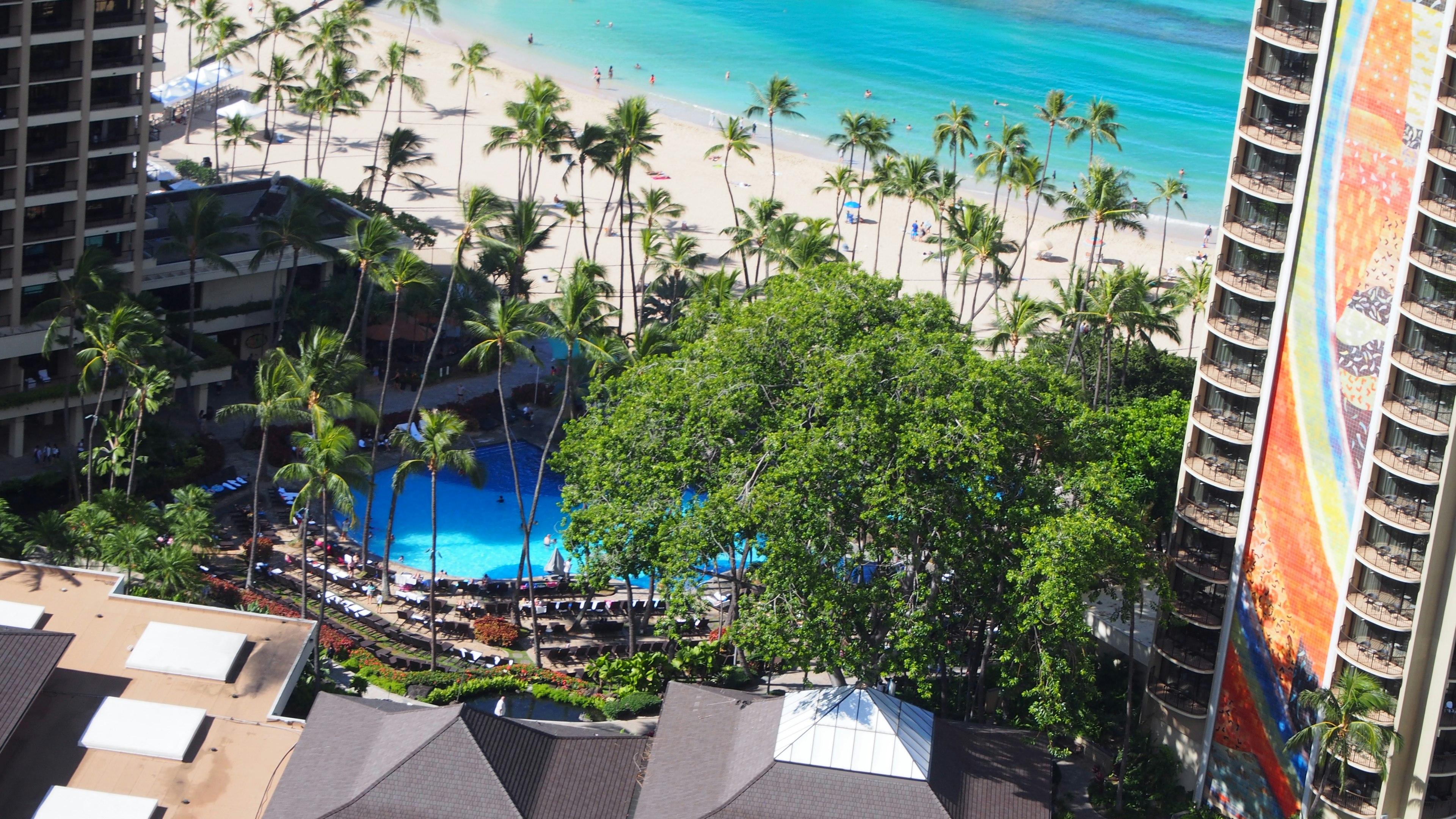 Panoramablick auf ein Resortgebiet mit blauem Ozean und weißem Sandstrand Pool umgeben von Palmen