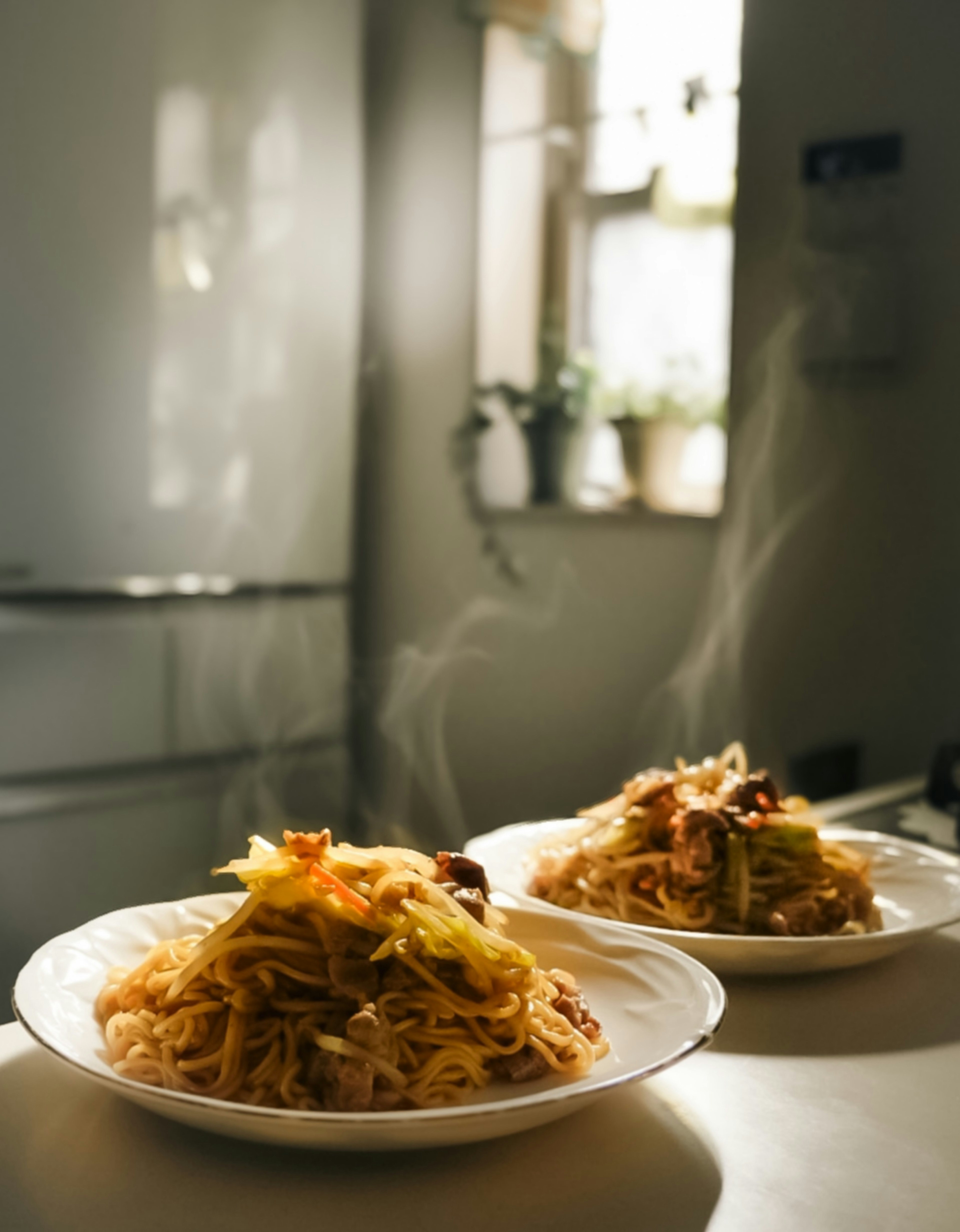 Two steaming plates of pasta served on a table