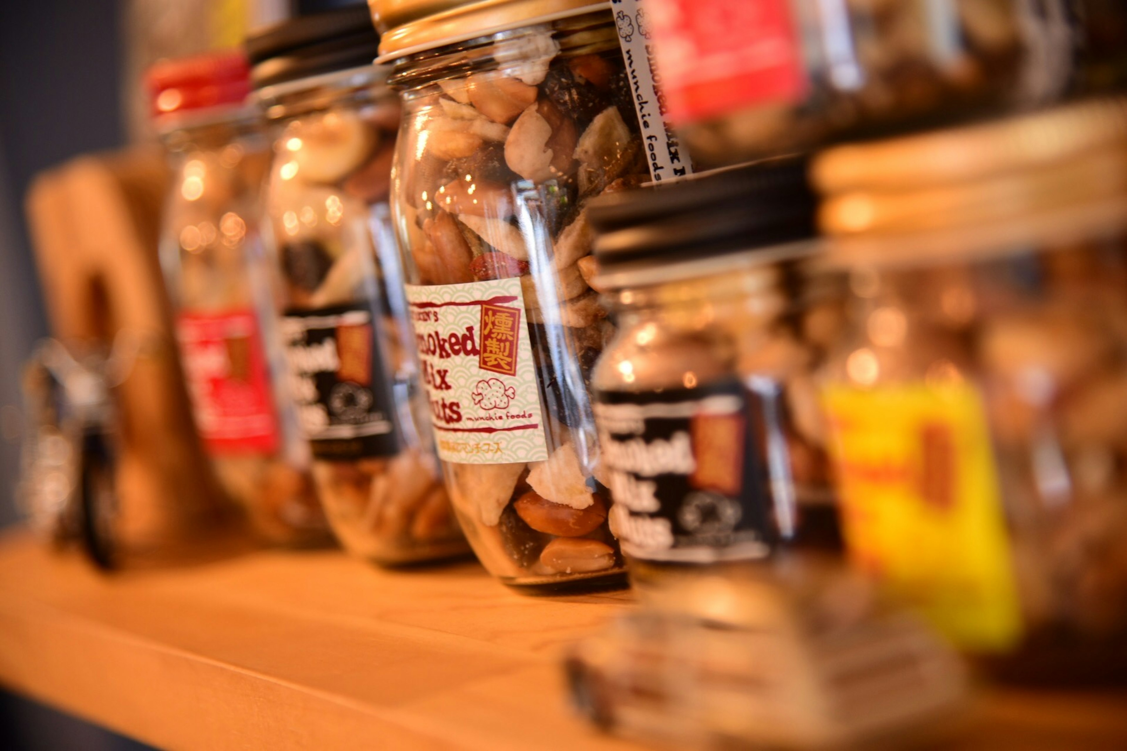 Various jars filled with nuts displayed on a wooden shelf