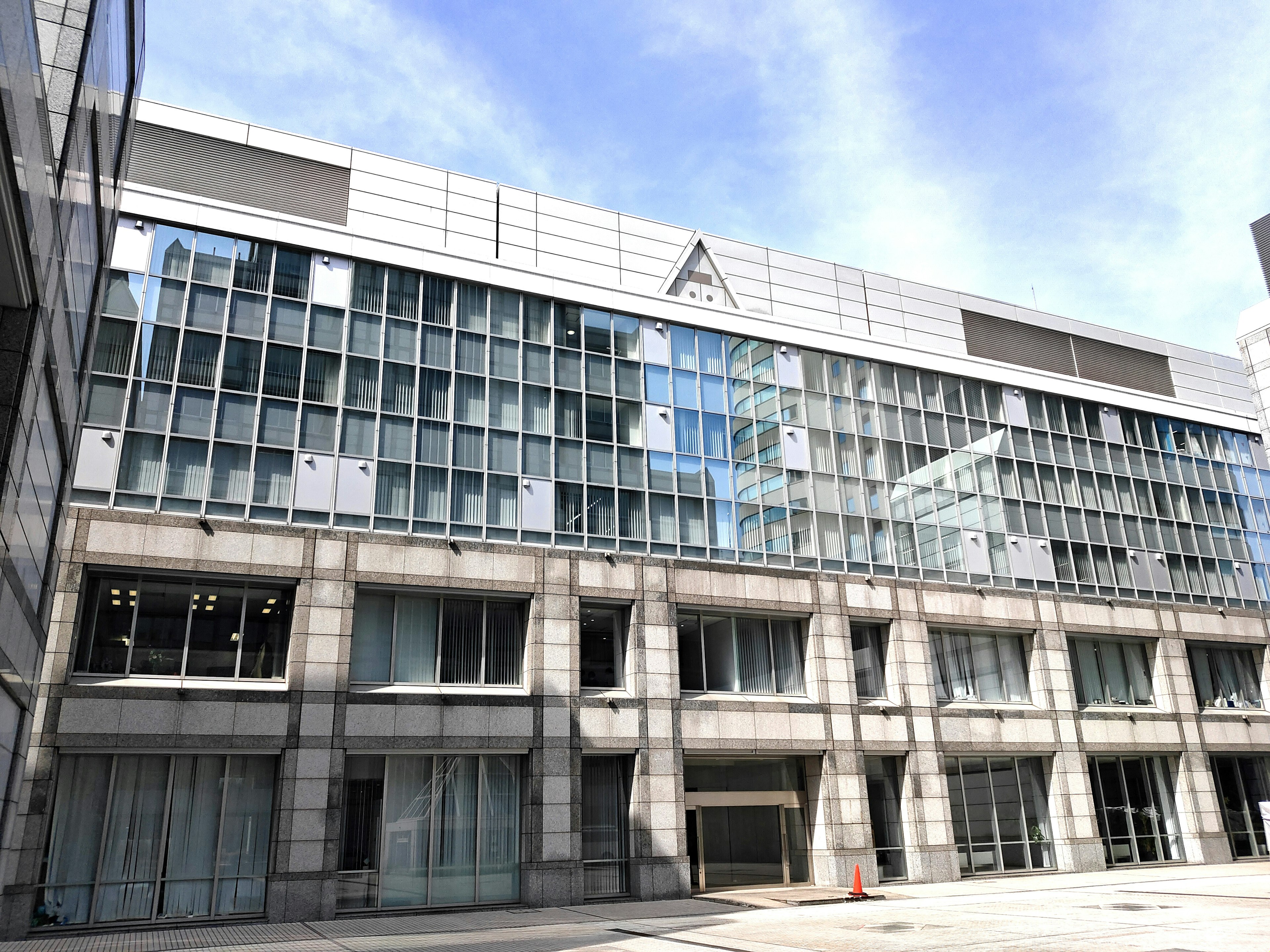 Exterior de un edificio moderno con fachada plateada y grandes ventanas de vidrio