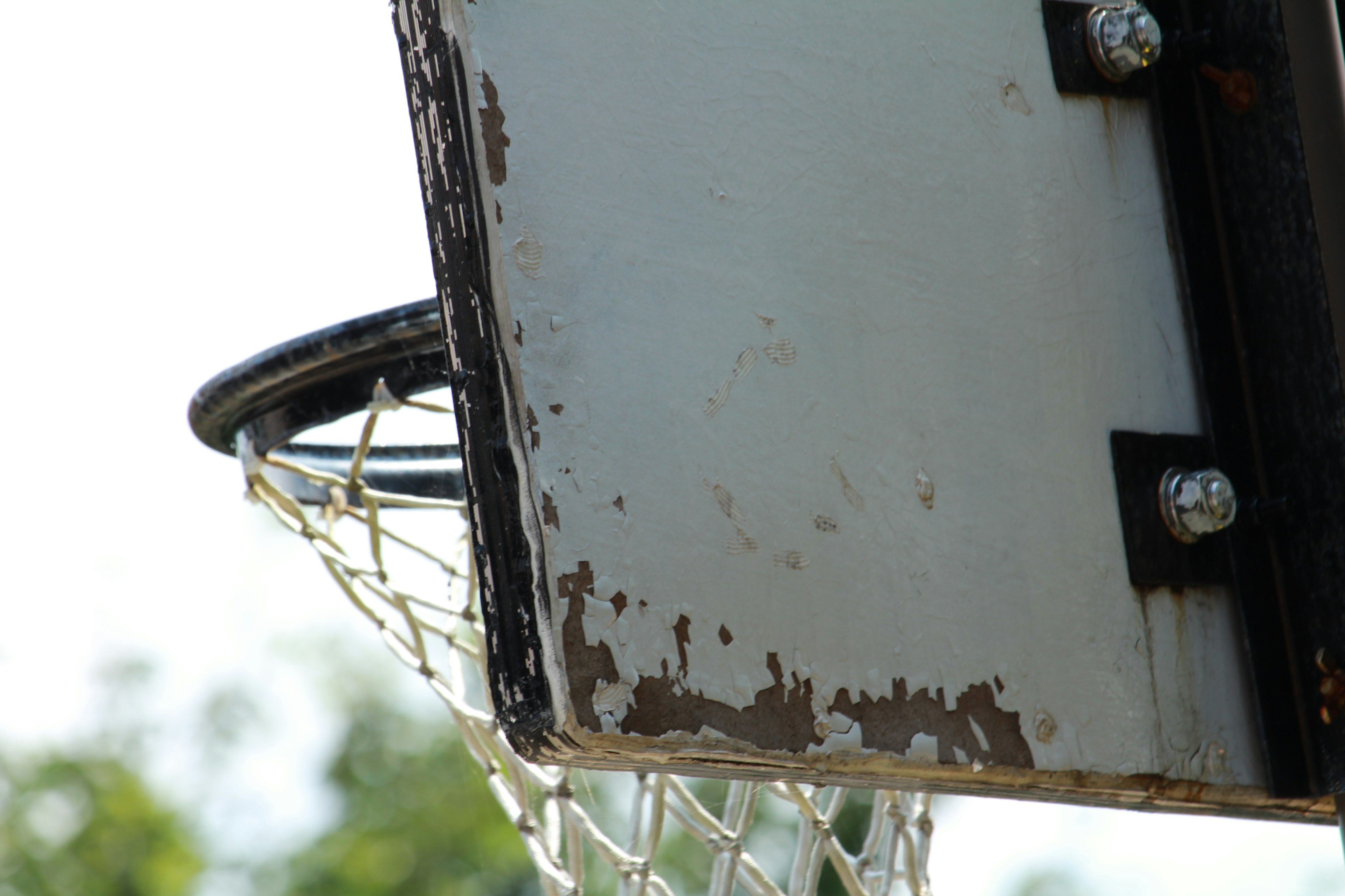 Nahaufnahme eines Basketballkorbs und eines abgenutzten Backboards