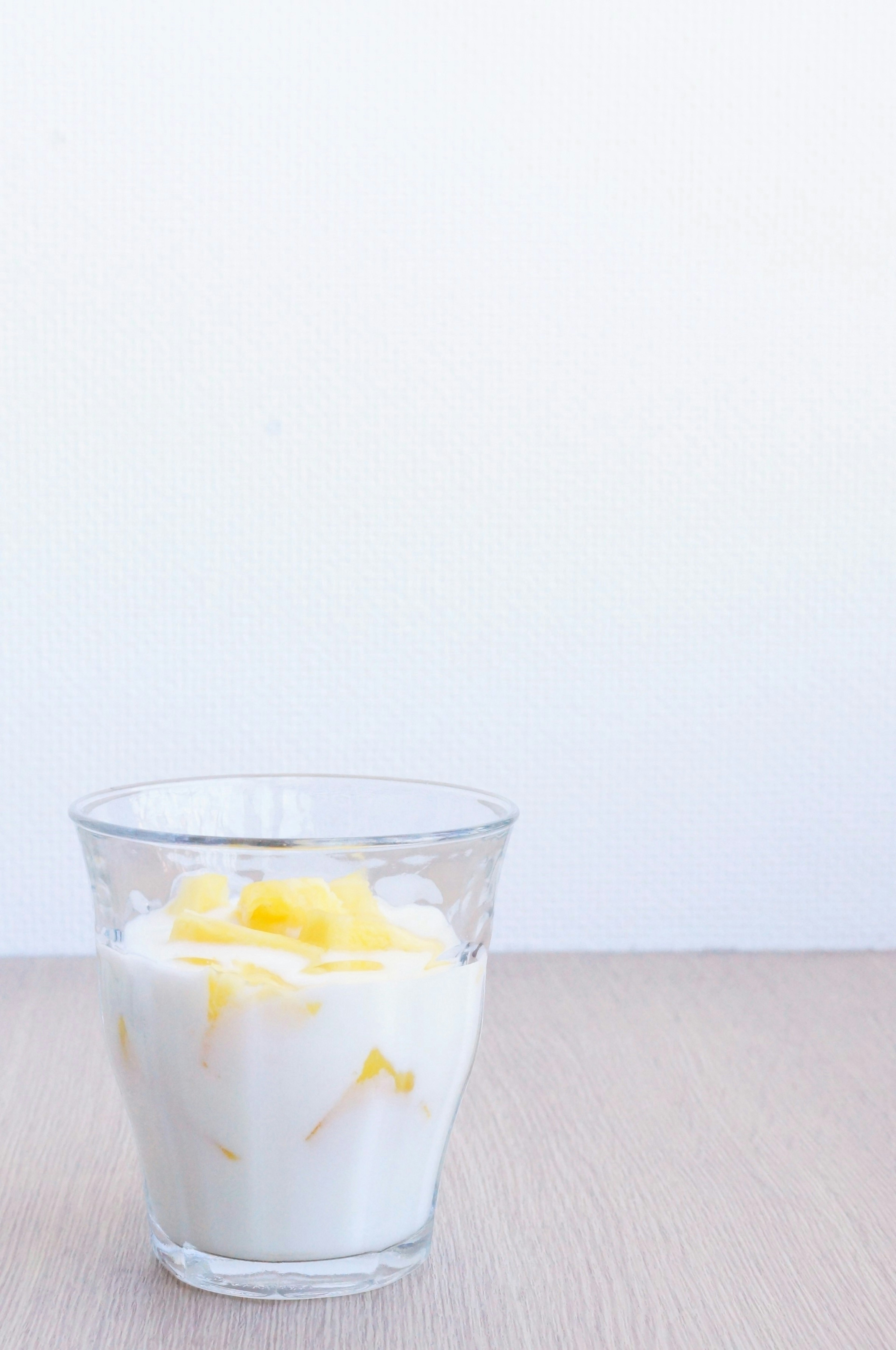 Yogurt dengan mangga di gelas transparan