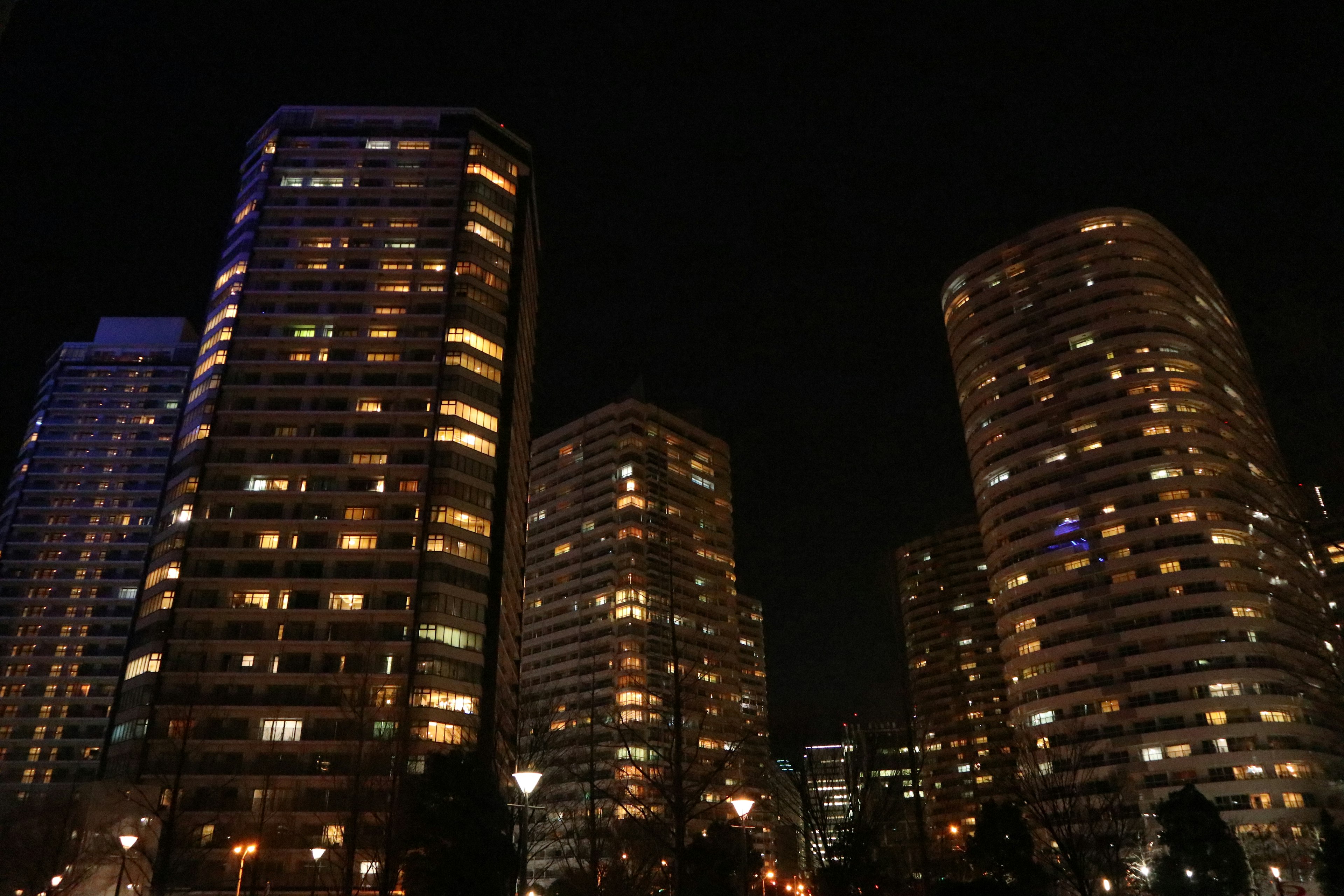 Night cityscape featuring tall buildings with illuminated windows