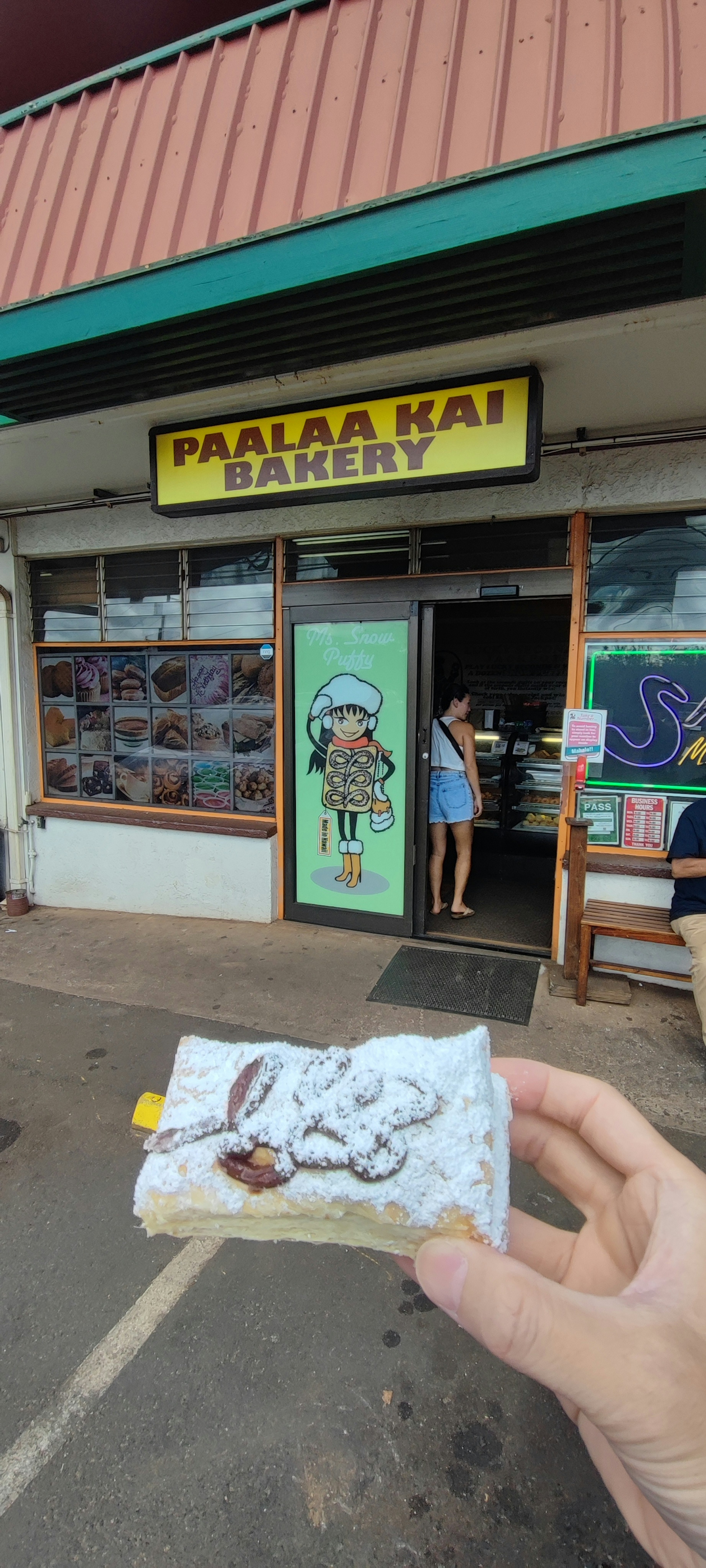 ภายนอกของ Pa'ia Kai Bakery พร้อมกับคนที่ถือขนมหวาน