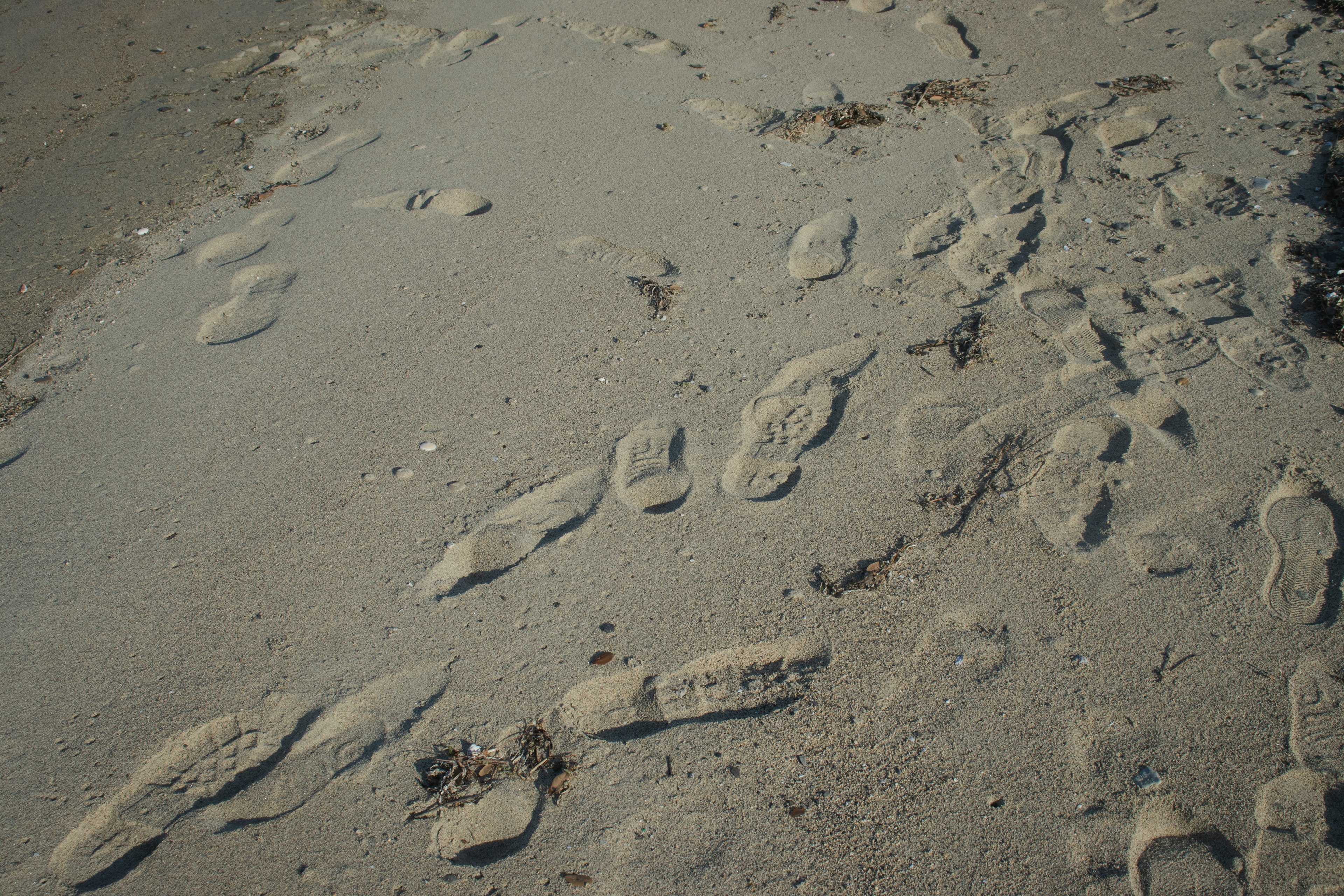 Fußabdrücke und natürliche Muster am Sandstrand