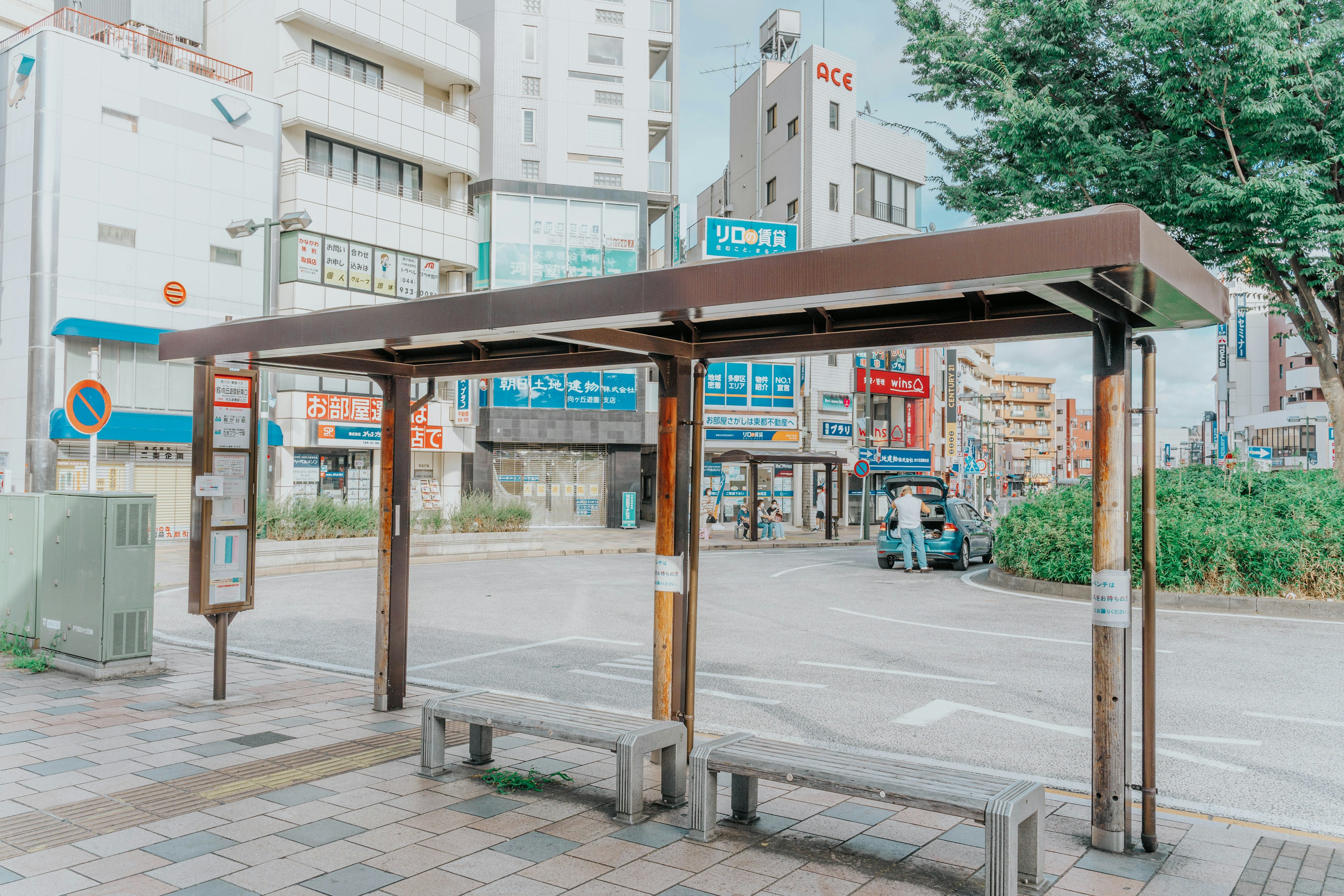 Structure simple d'un arrêt de bus avec des bâtiments en arrière-plan