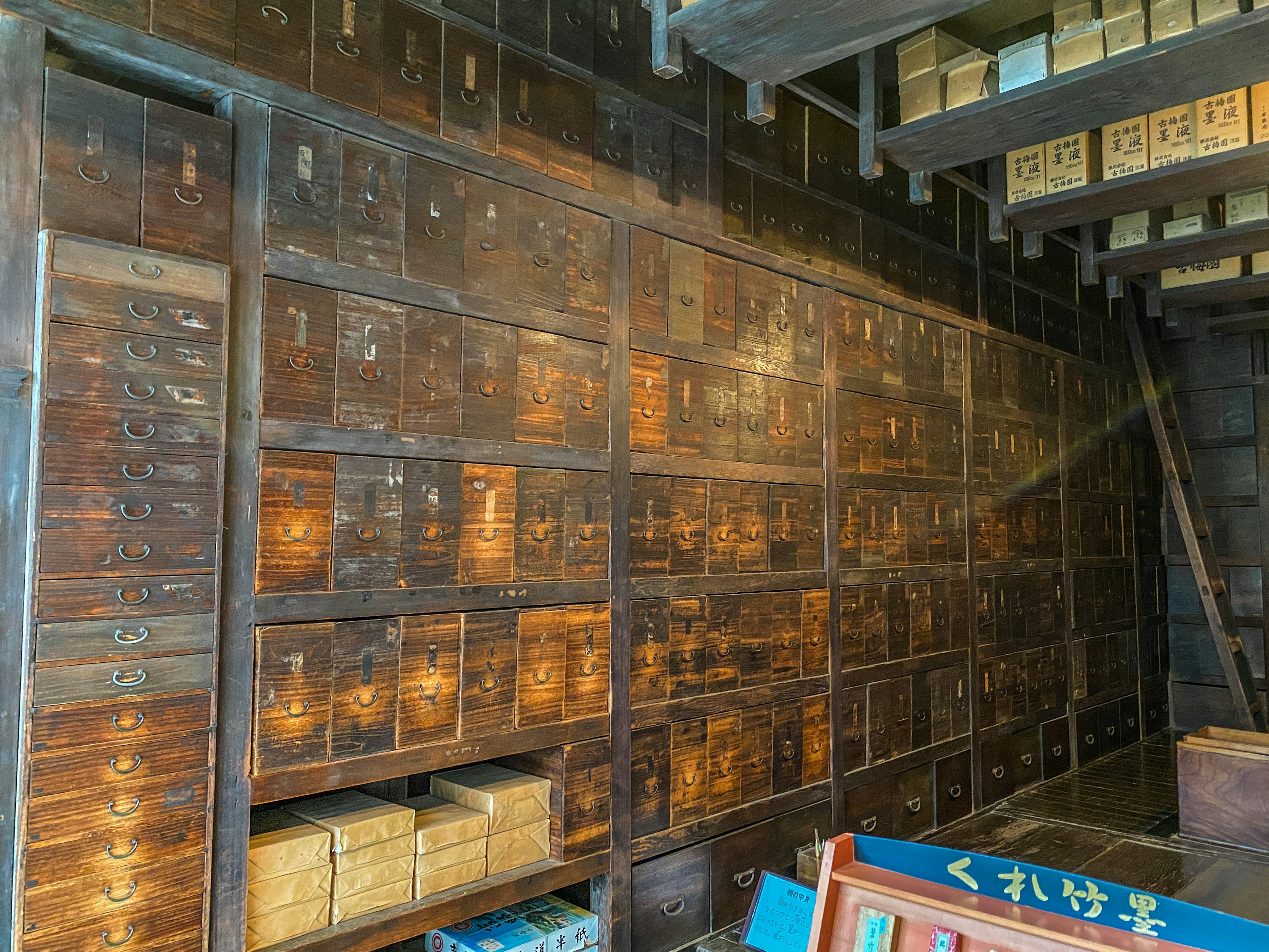 Interno di una vecchia biblioteca con cassetti in legno allineati sulla parete