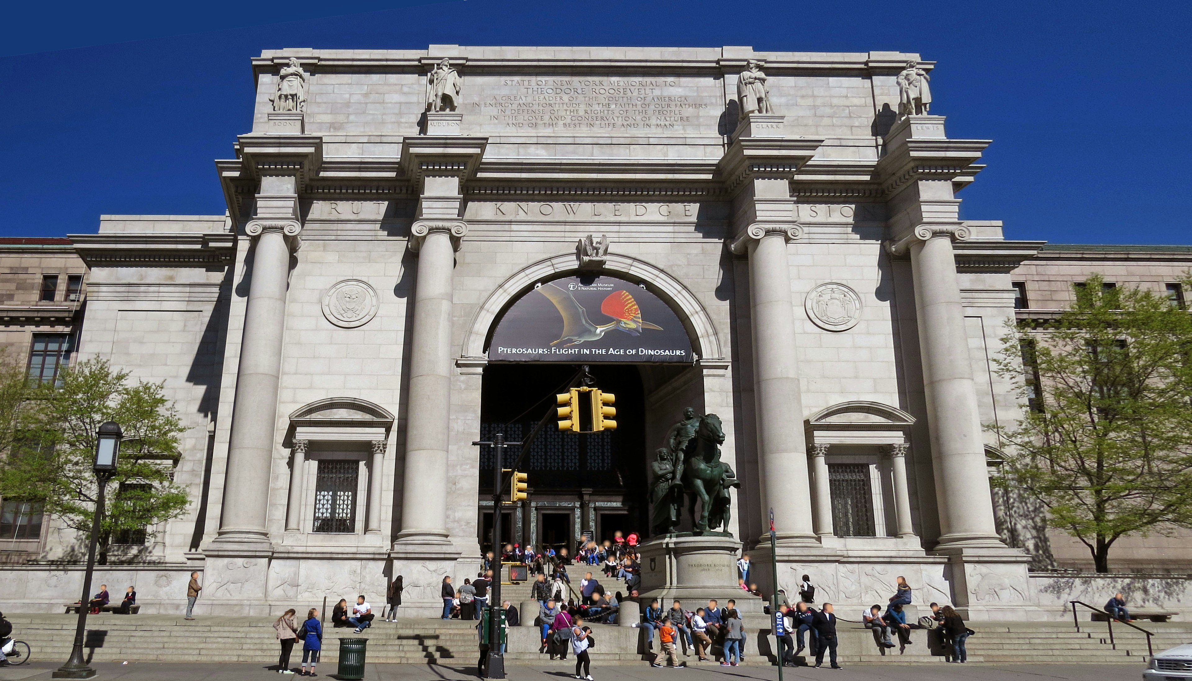 Exterior of the American Museum of Natural History in New York with numerous visitors at the entrance