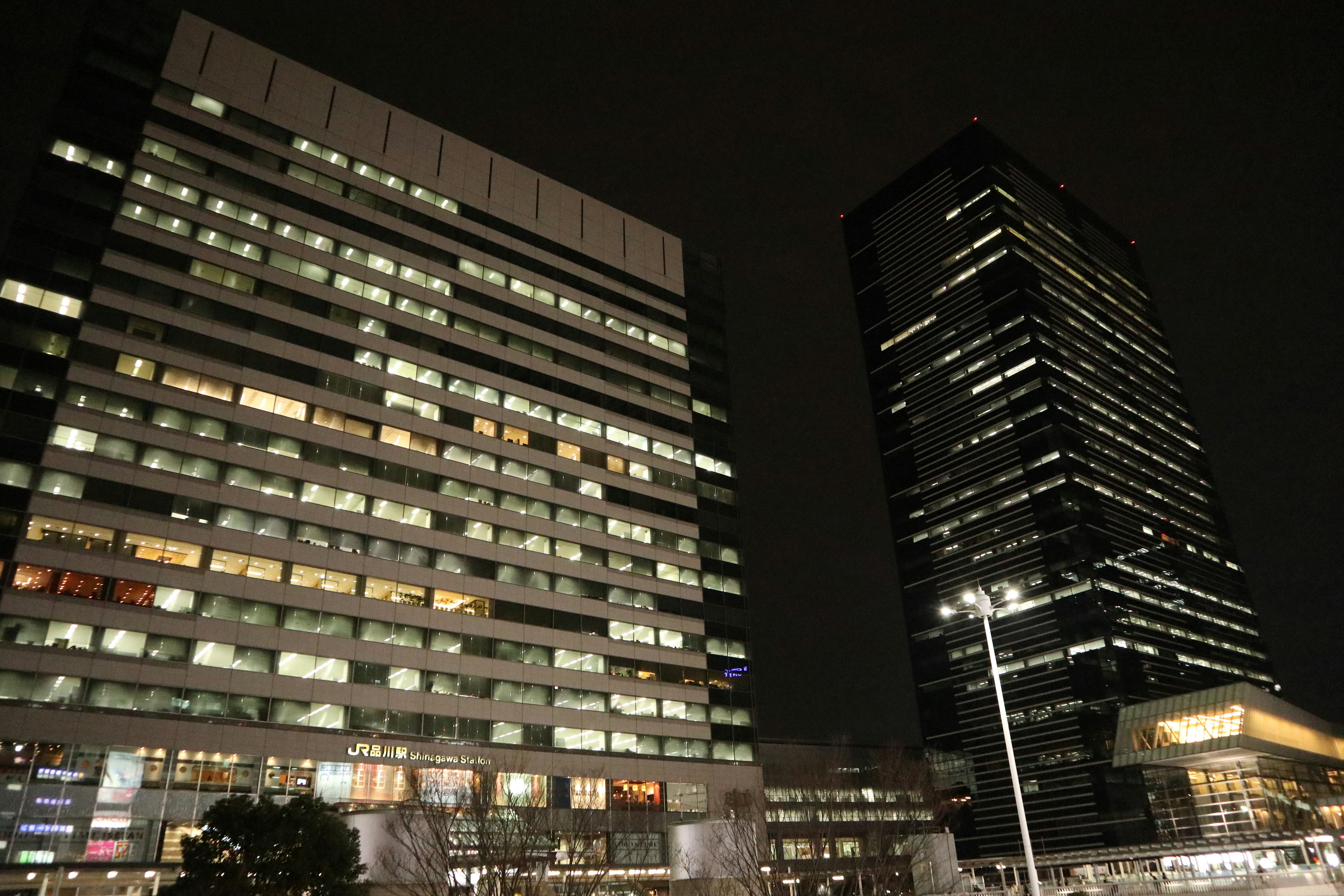 Night cityscape featuring high-rise buildings with illuminated windows