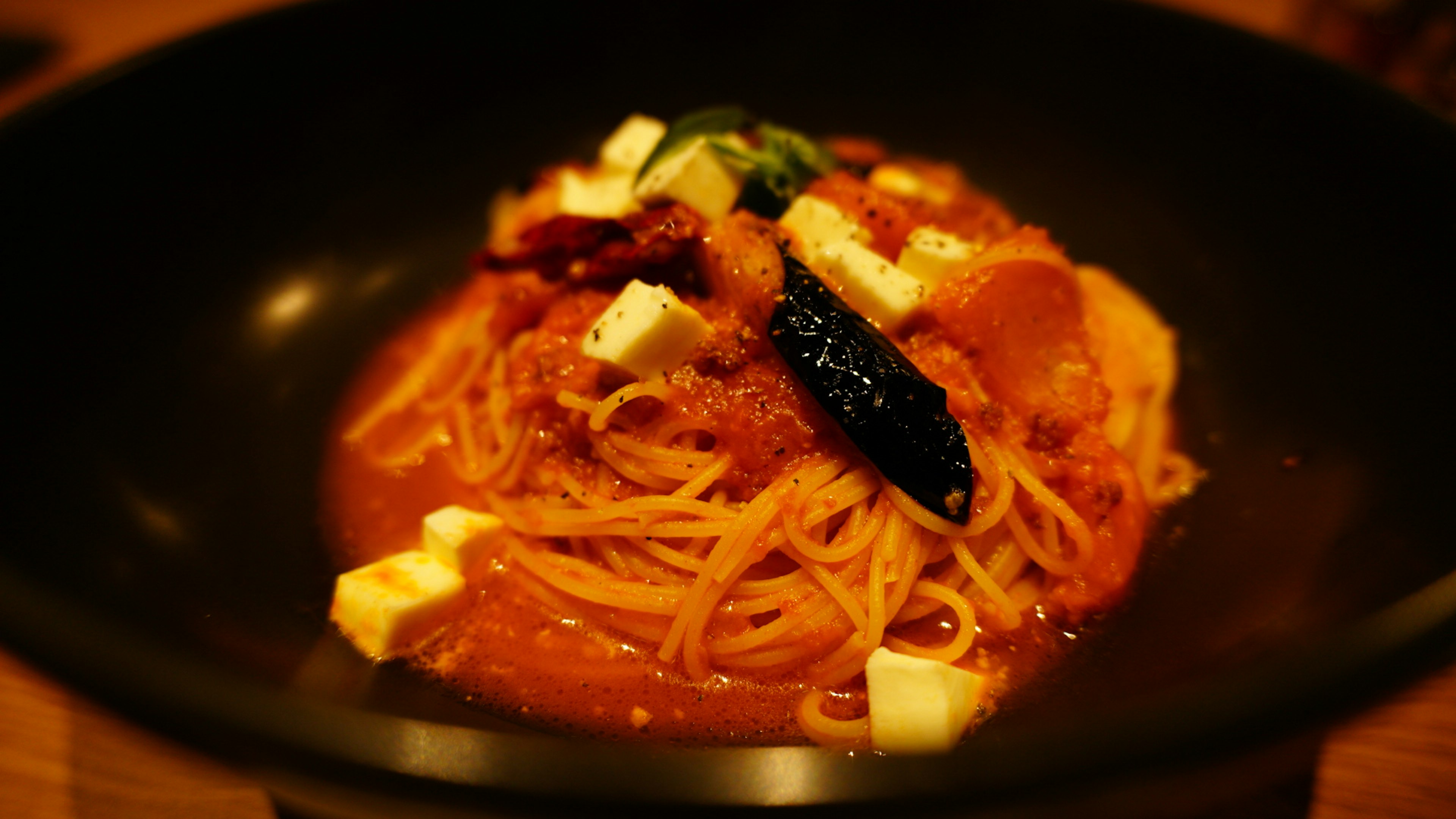 Spaghetti mit Tomatensauce, garniert mit Käse und Kräutern