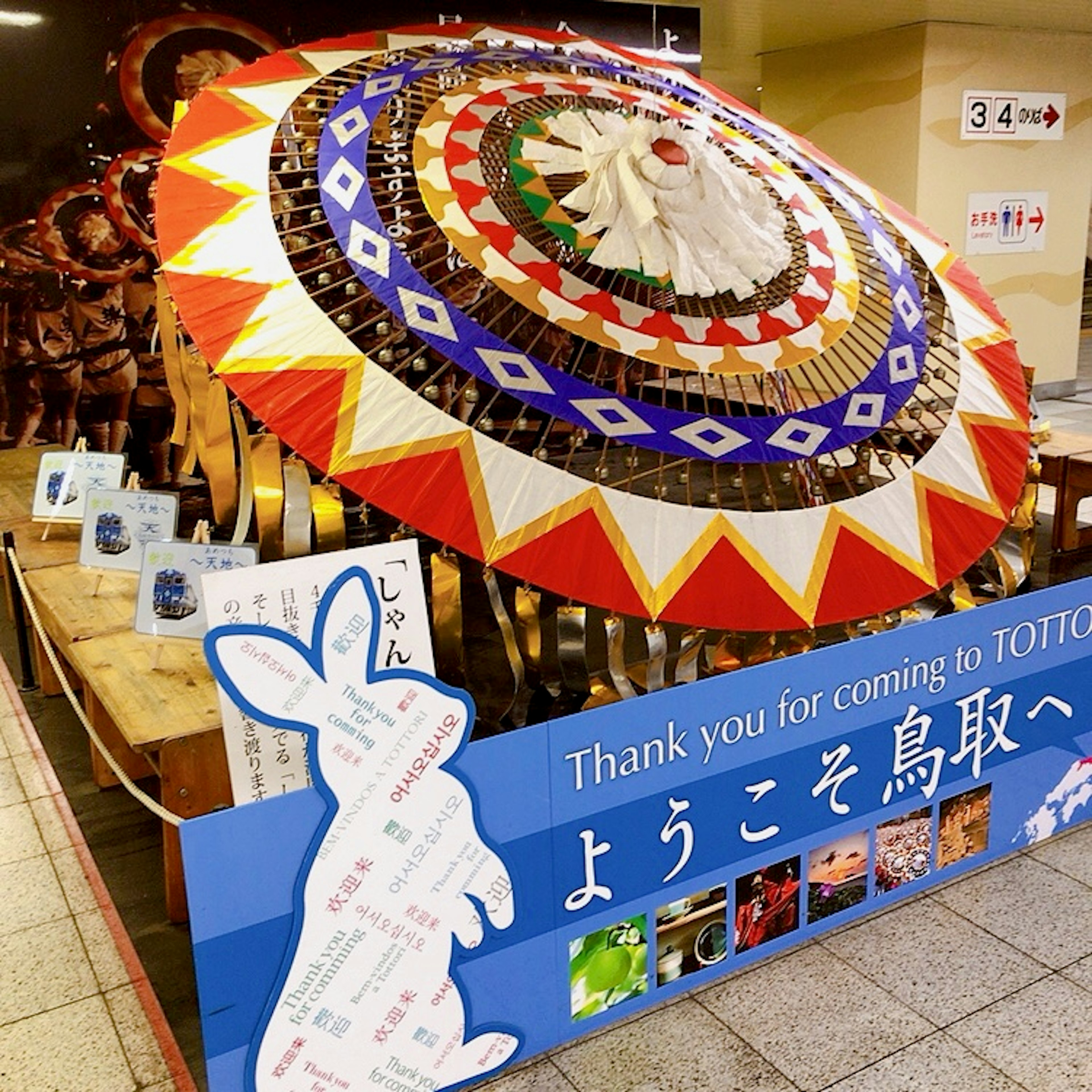 Decorative umbrella and welcome sign at Tottori tourist information center