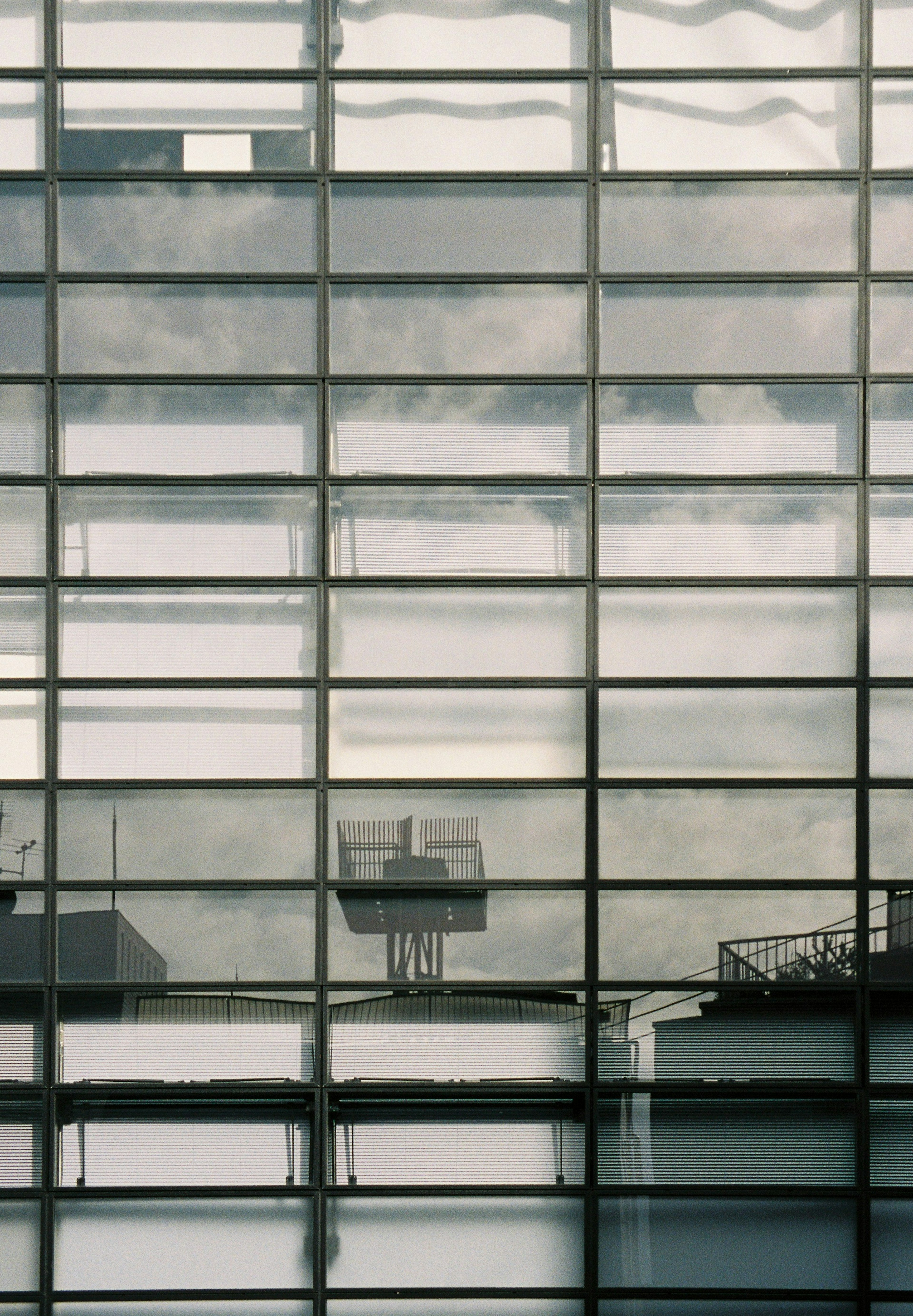 Reflejo de nubes y siluetas de edificios en ventanas de cristal