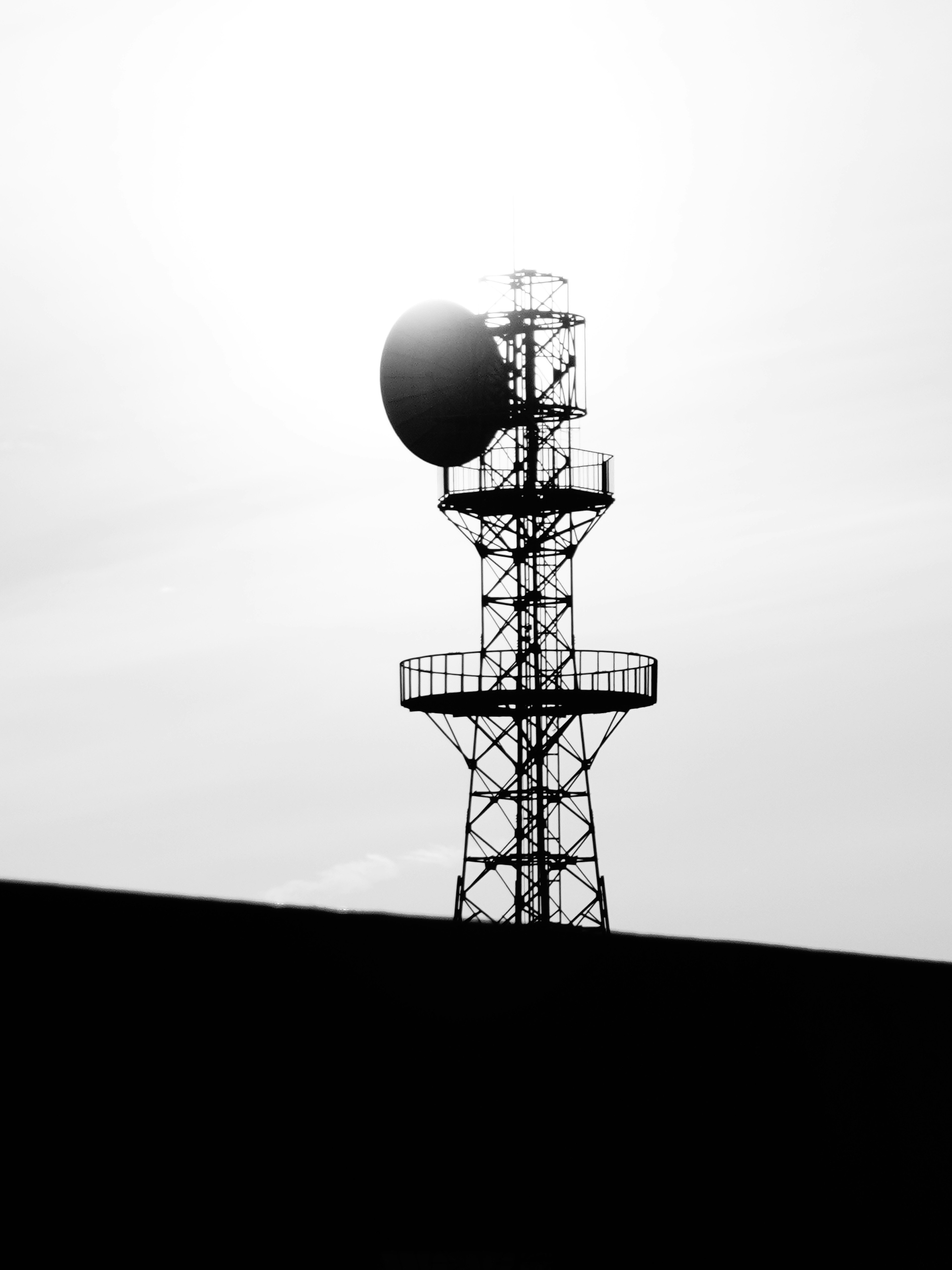 Silhouette d'une tour de communication avec une grande antenne sur fond clair