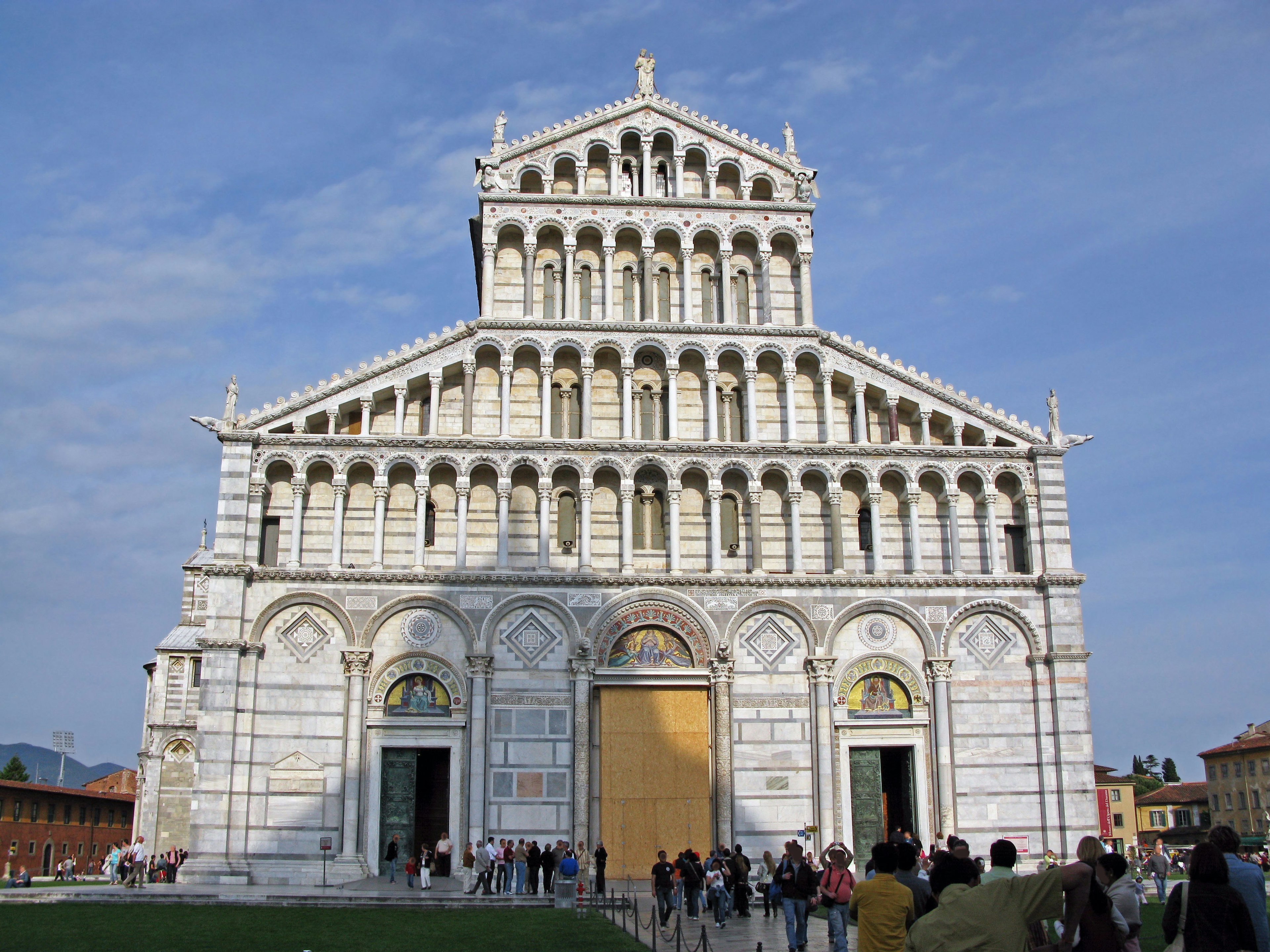 The grand facade of Pisa Cathedral with visitors