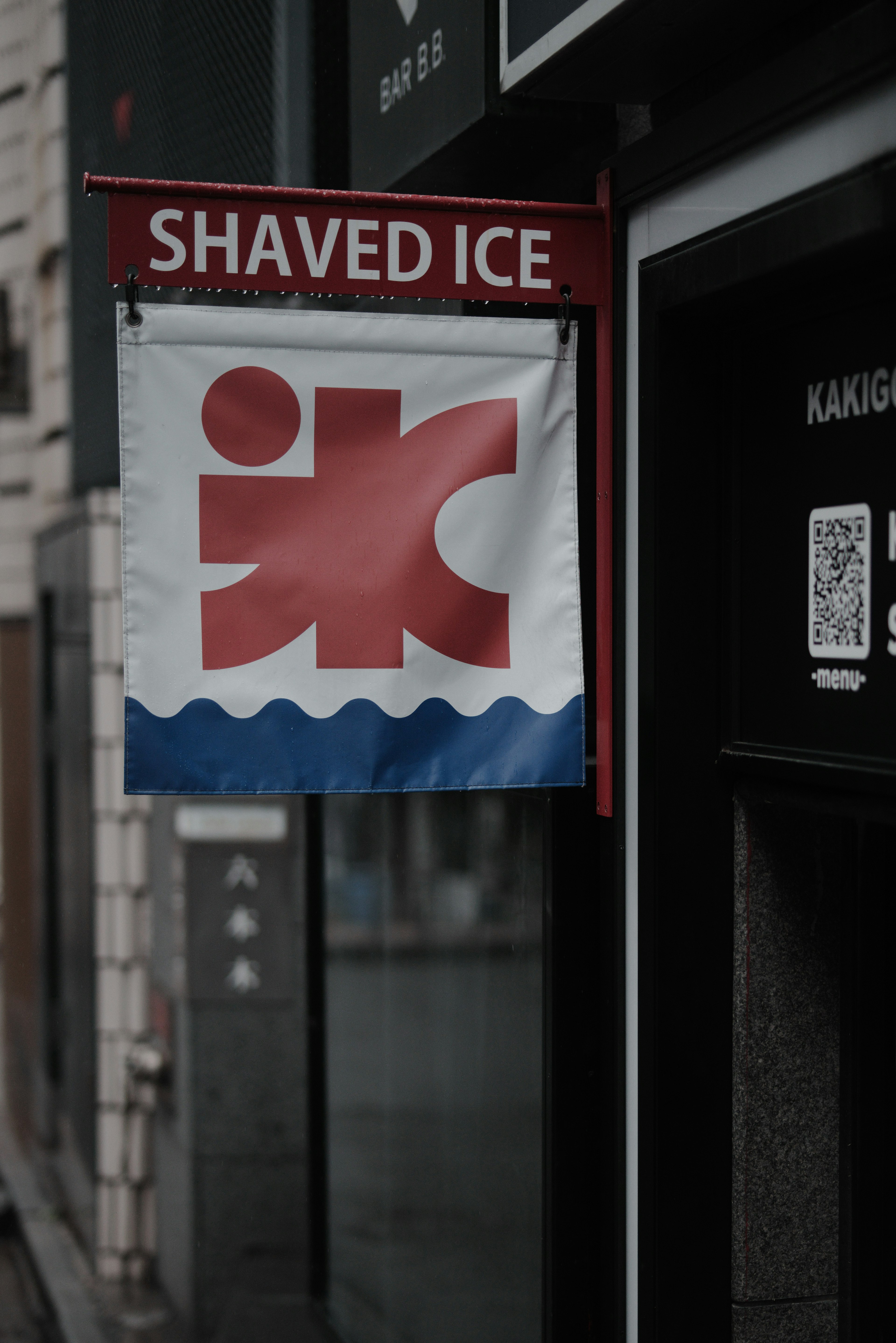 Red sign displaying shaved ice with wave pattern design