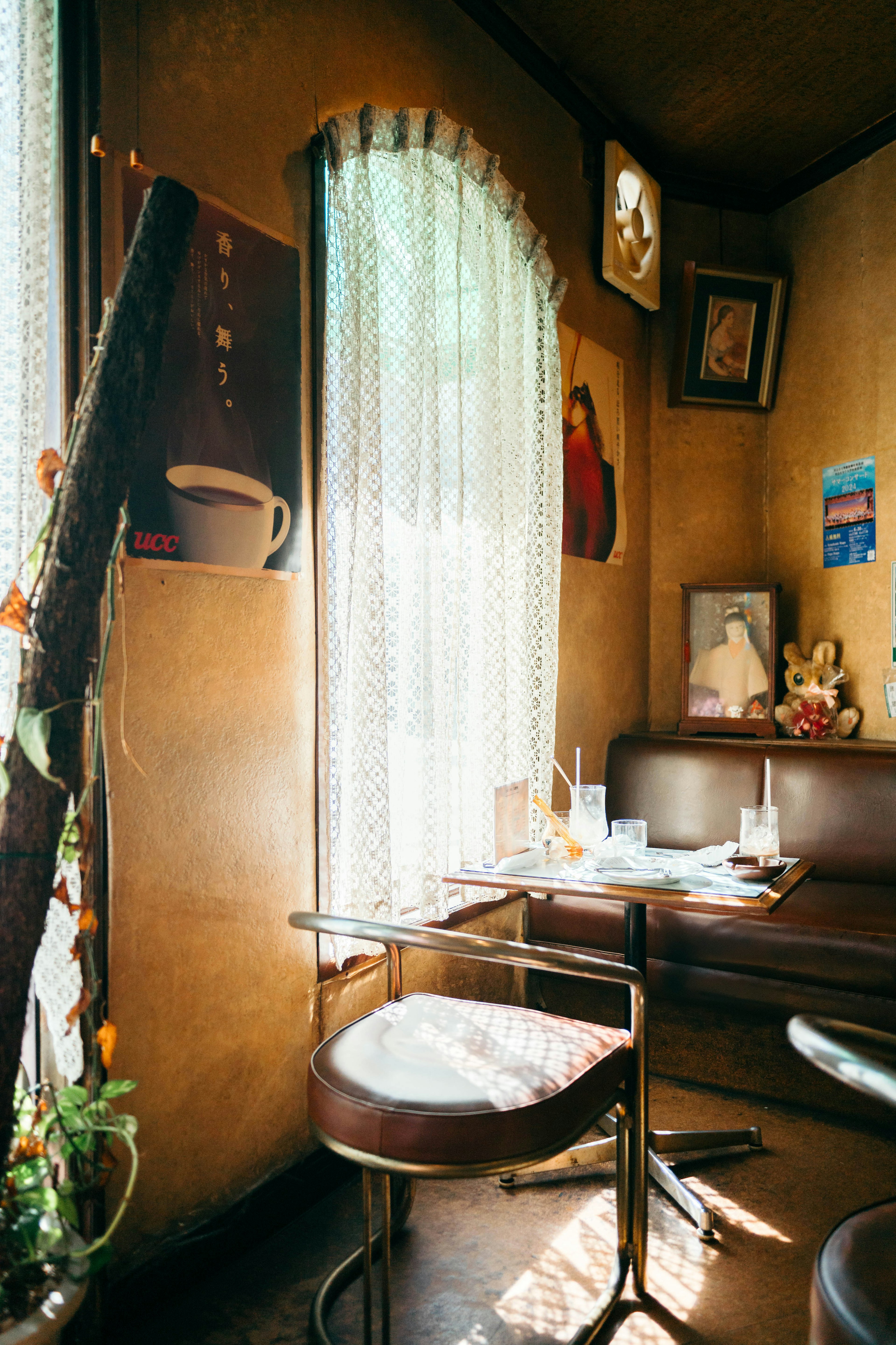 Interior acogedor de una cafetería con una mesa y una silla iluminadas por la luz natural de la ventana