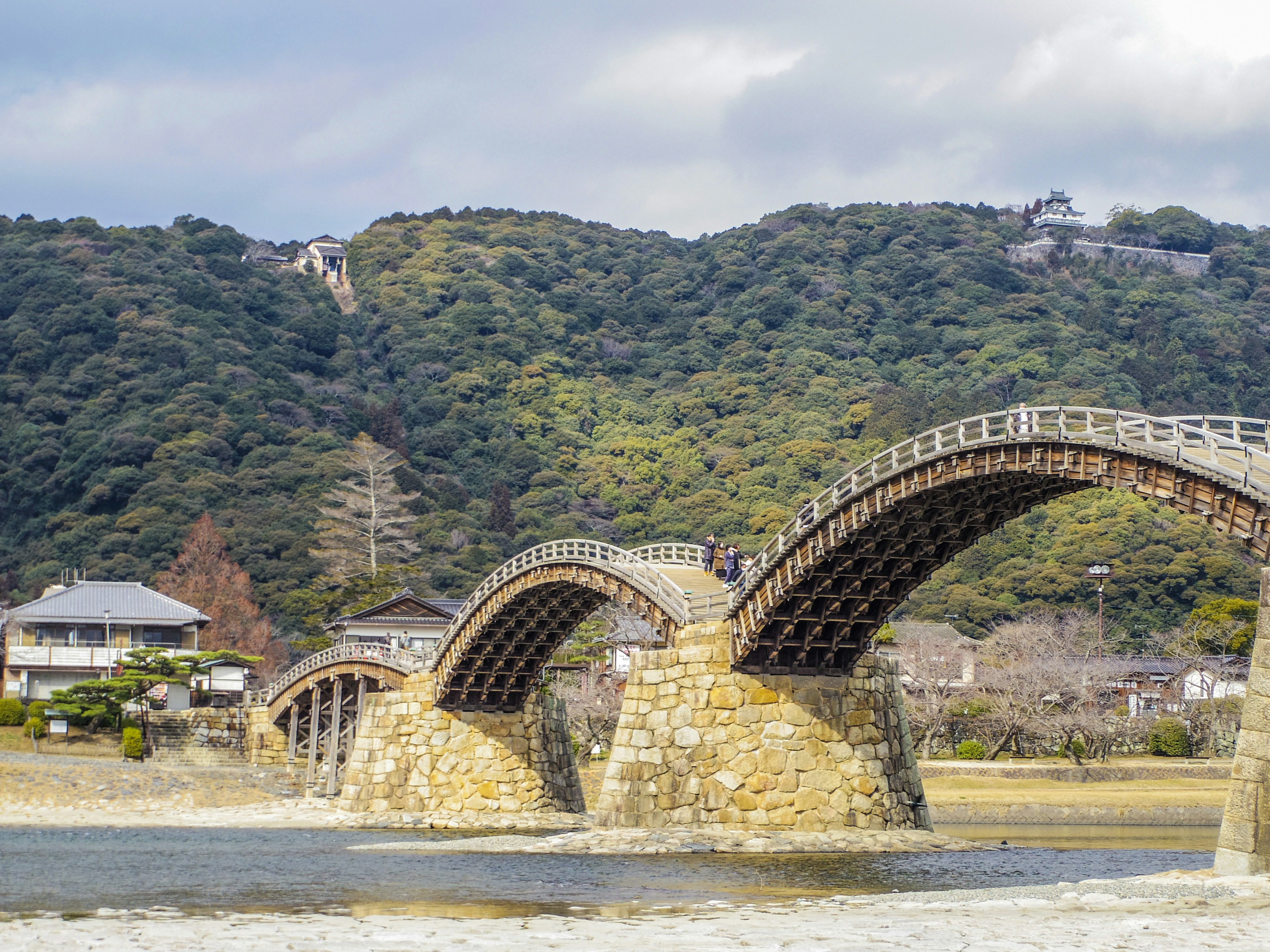 Puente arqueado de madera con paisaje montañoso circundante