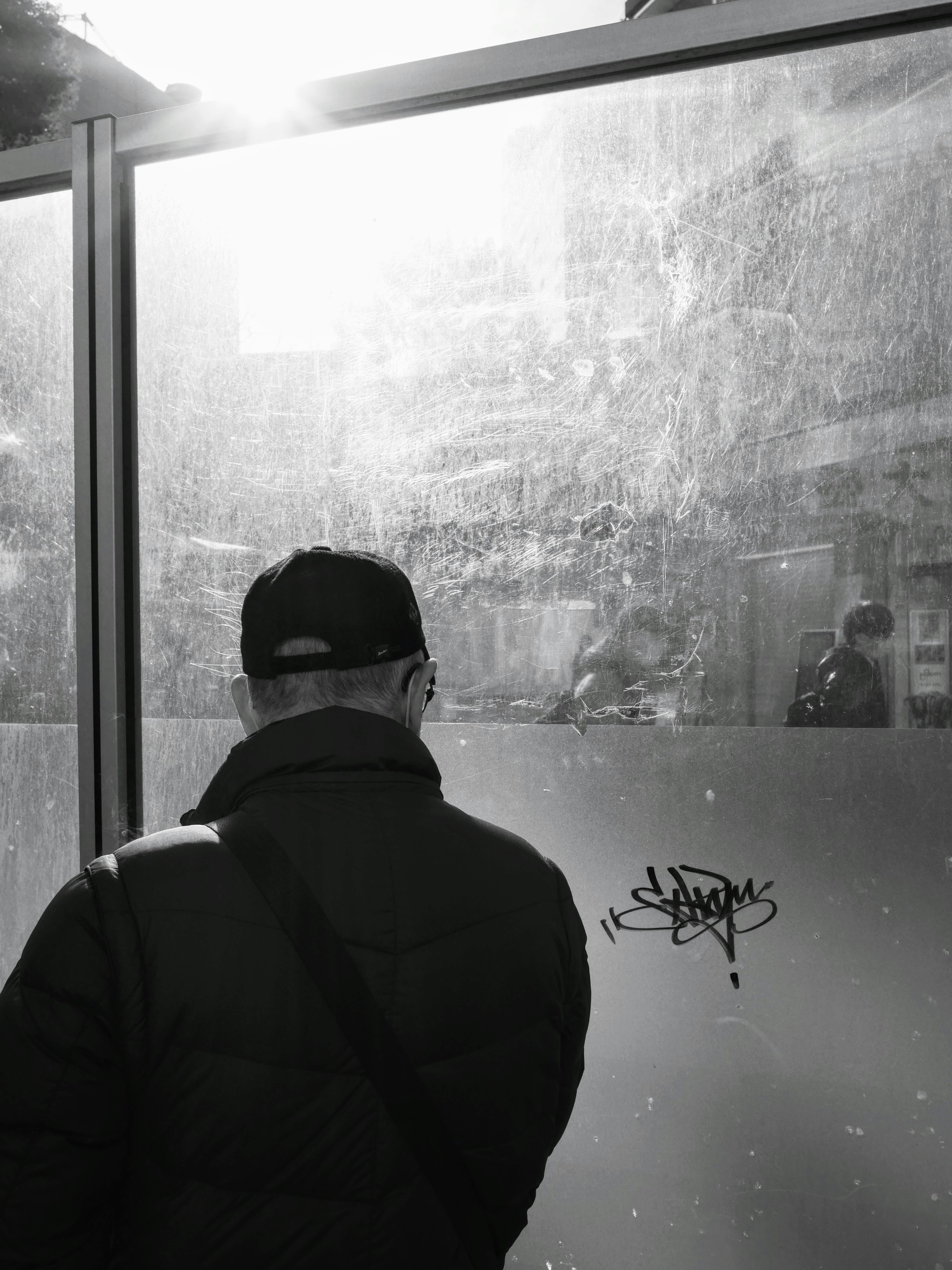 A man with his back turned and a foggy glass background light shining through