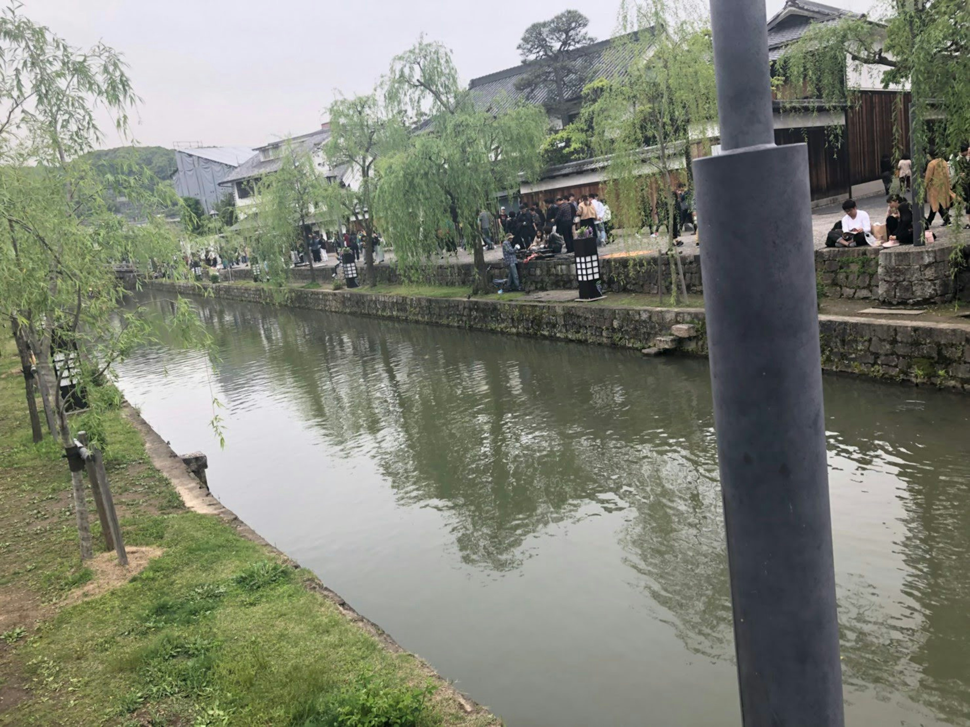 Serene river view with willow trees and people