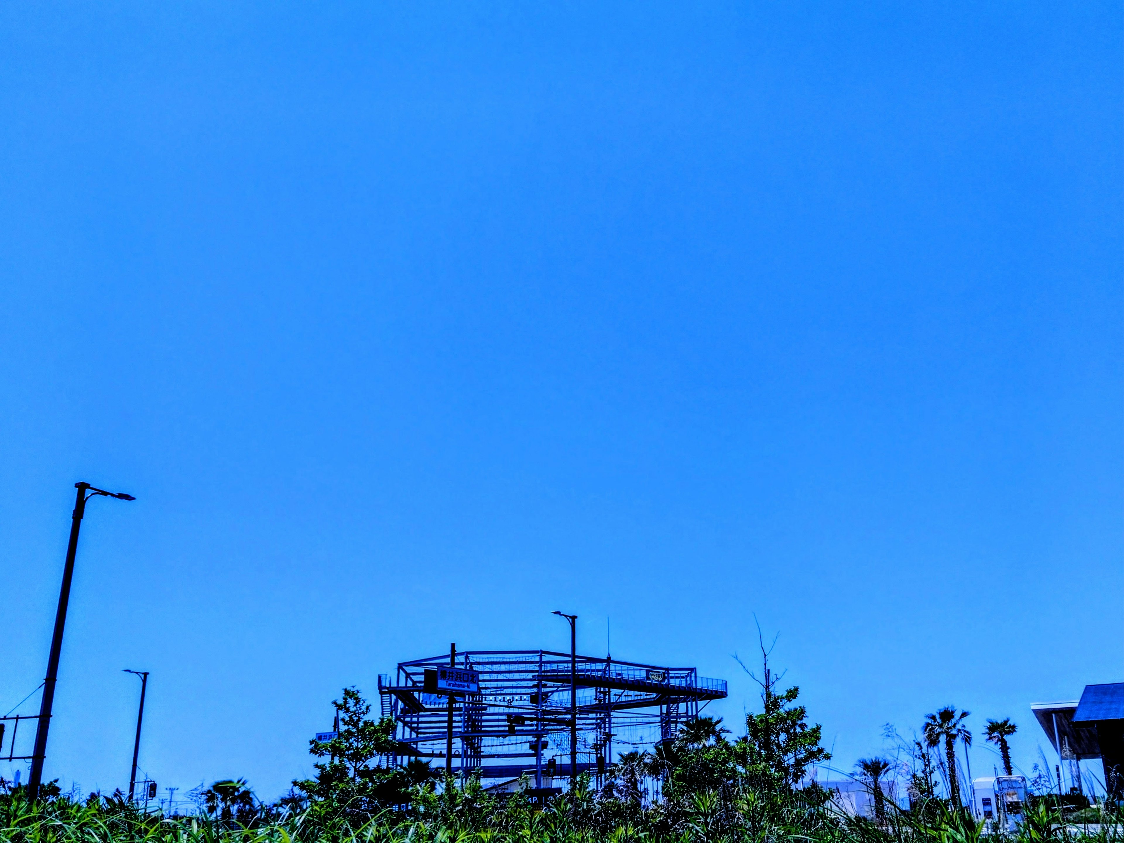 Estructura en construcción bajo un cielo azul claro con vegetación circundante