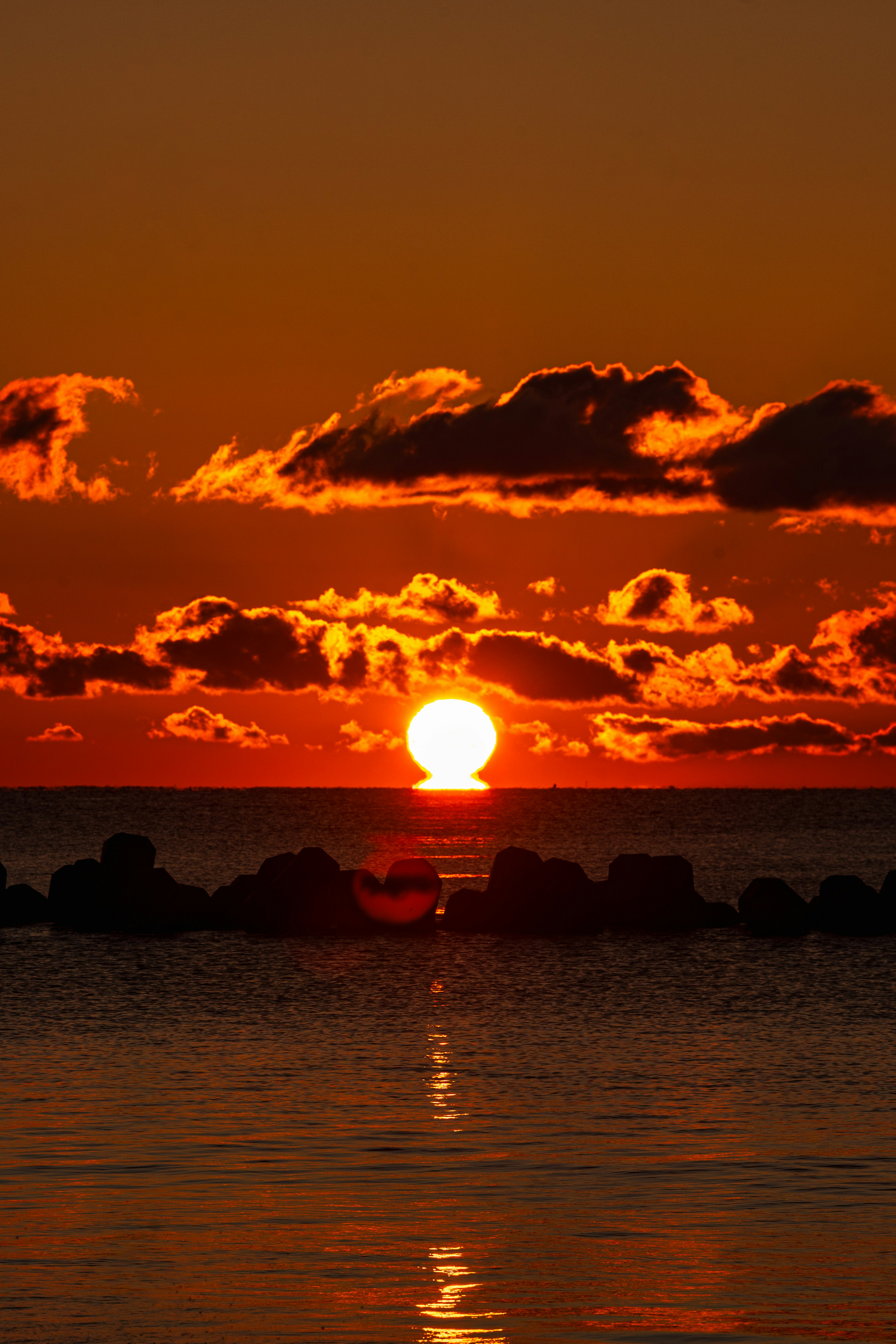 夕日が海に沈む美しい風景オレンジ色の空と雲の反射