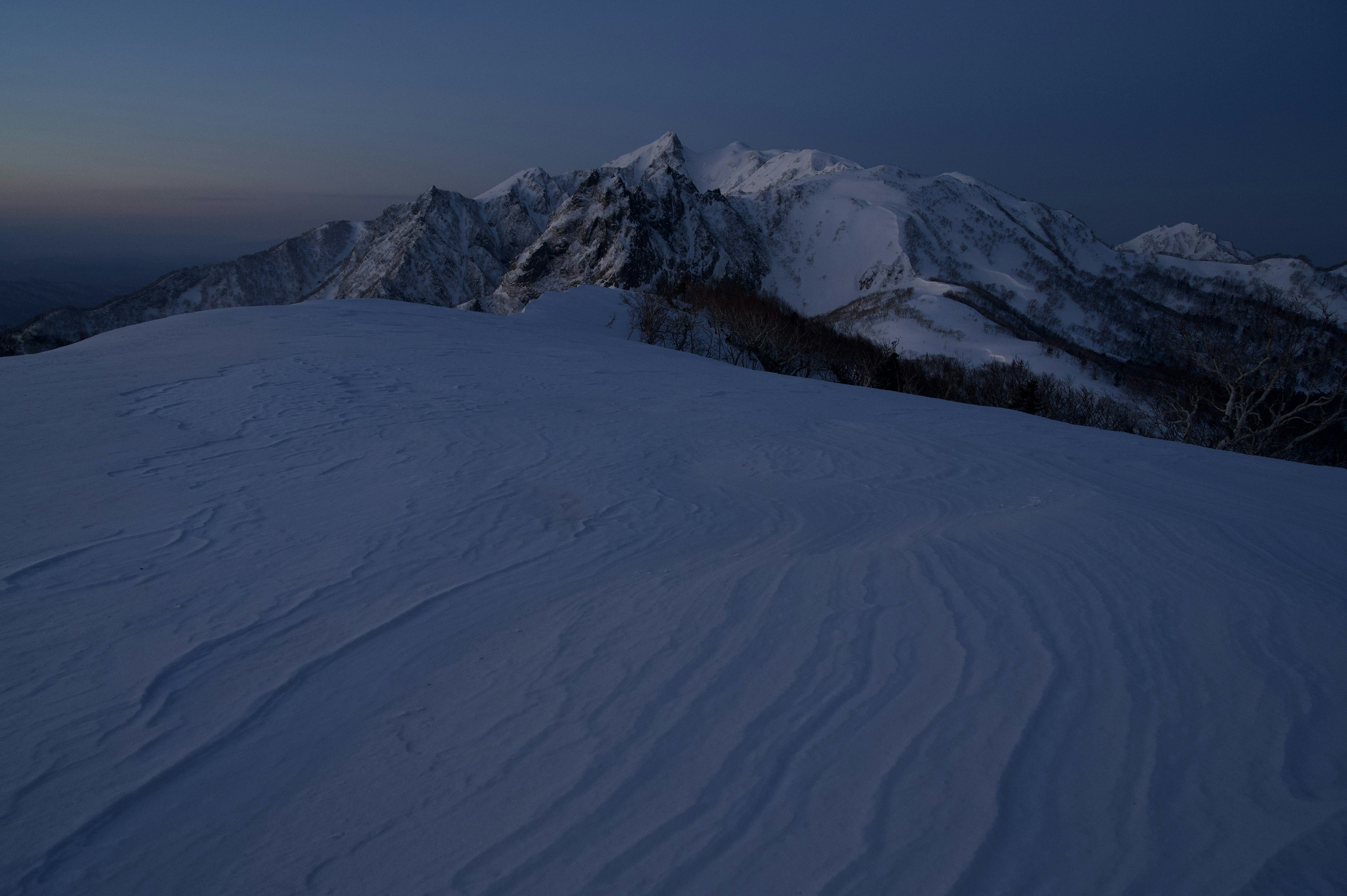 Vue nocturne des montagnes enneigées avec des courbes douces