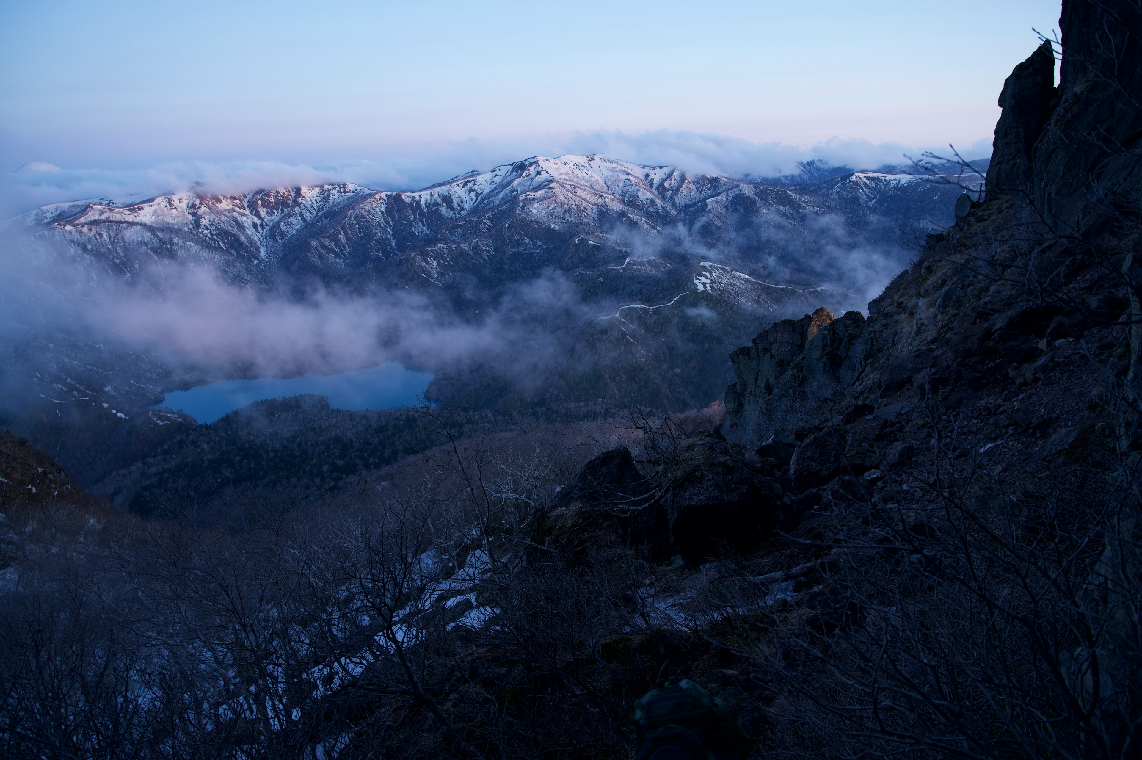 霧の中の山々と雪に覆われた風景で冷たい青い空