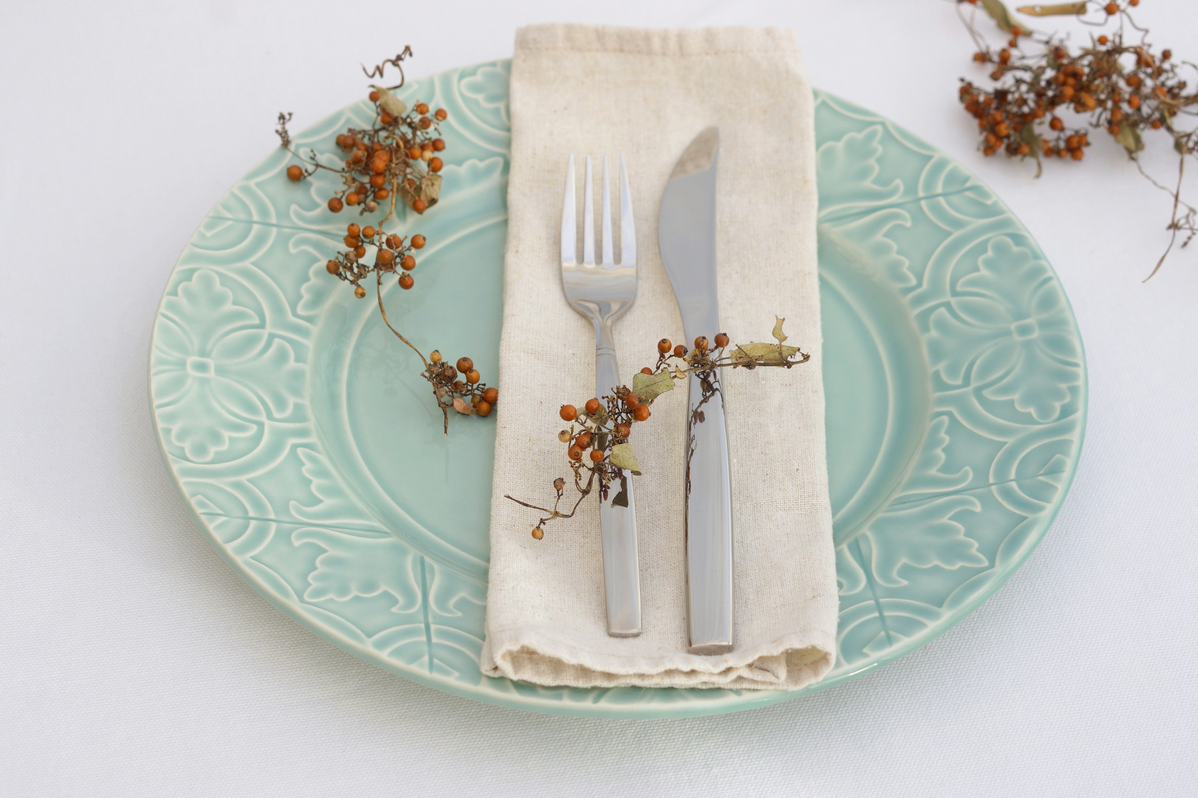 Mise en place élégante avec une serviette et des couverts sur une assiette bleue