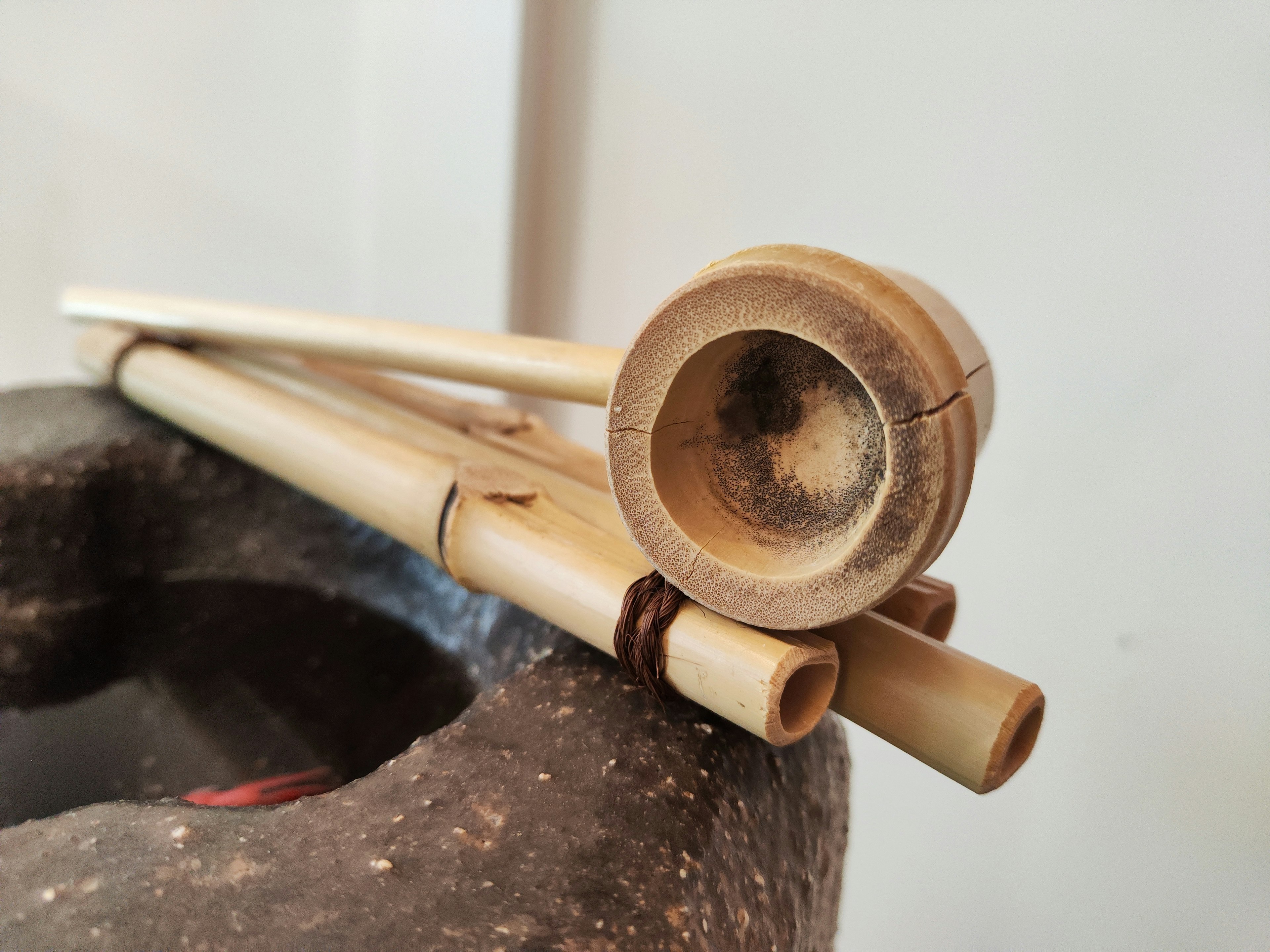 Close-up of bamboo musical instruments and a clay vessel