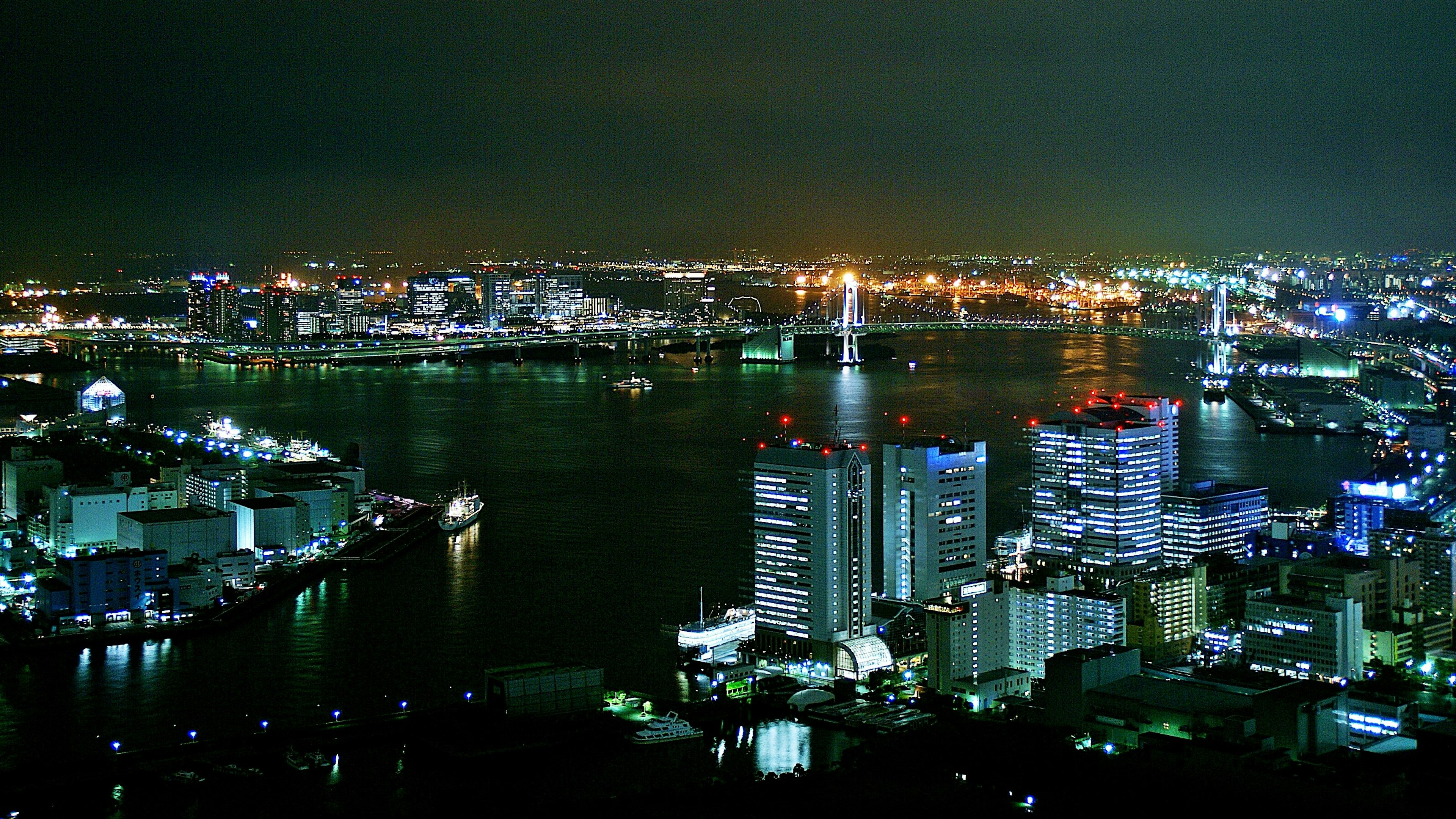 Vista notturna di uno skyline urbano con un fiume e edifici illuminati