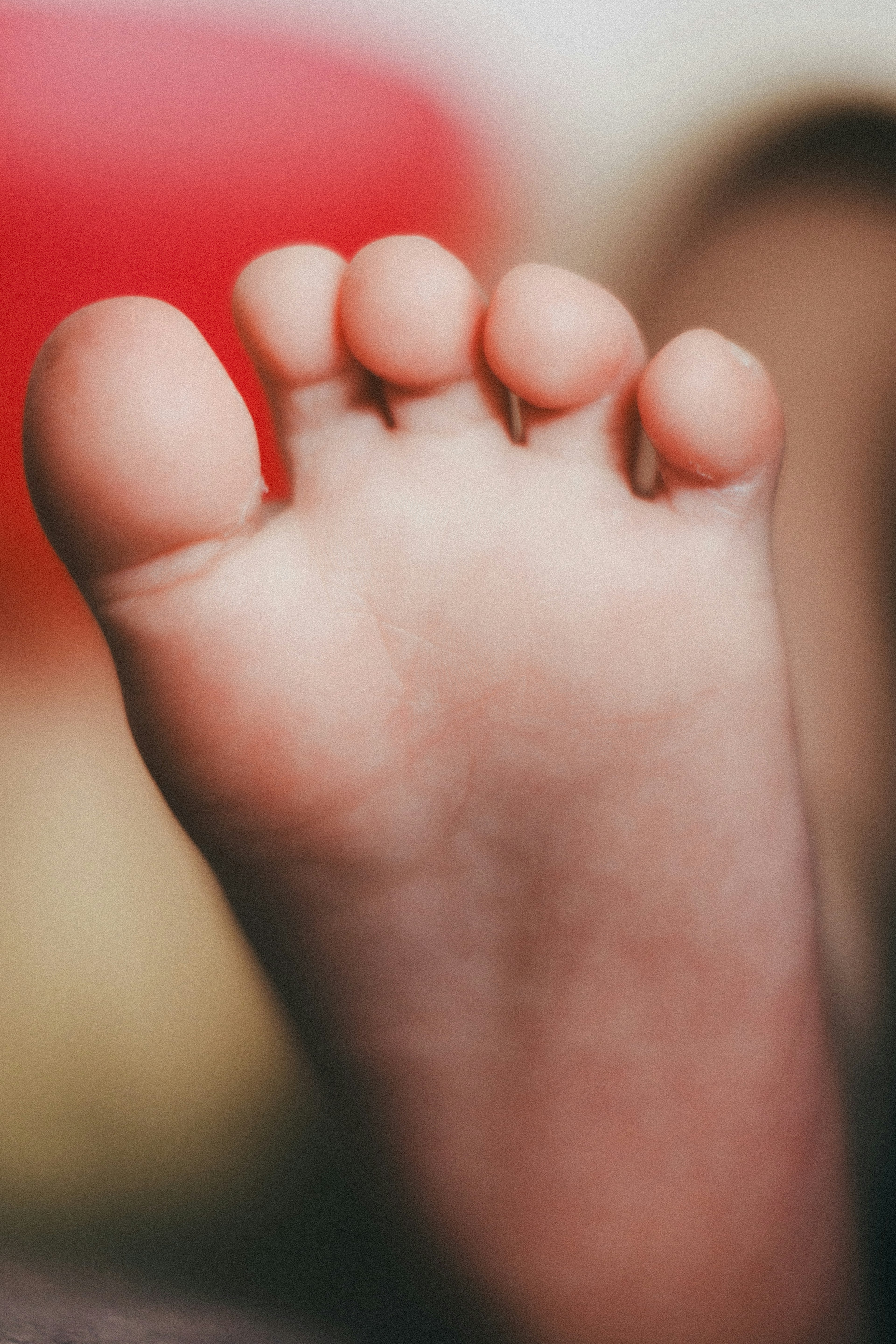 Close-up kaki anak dengan latar belakang merah