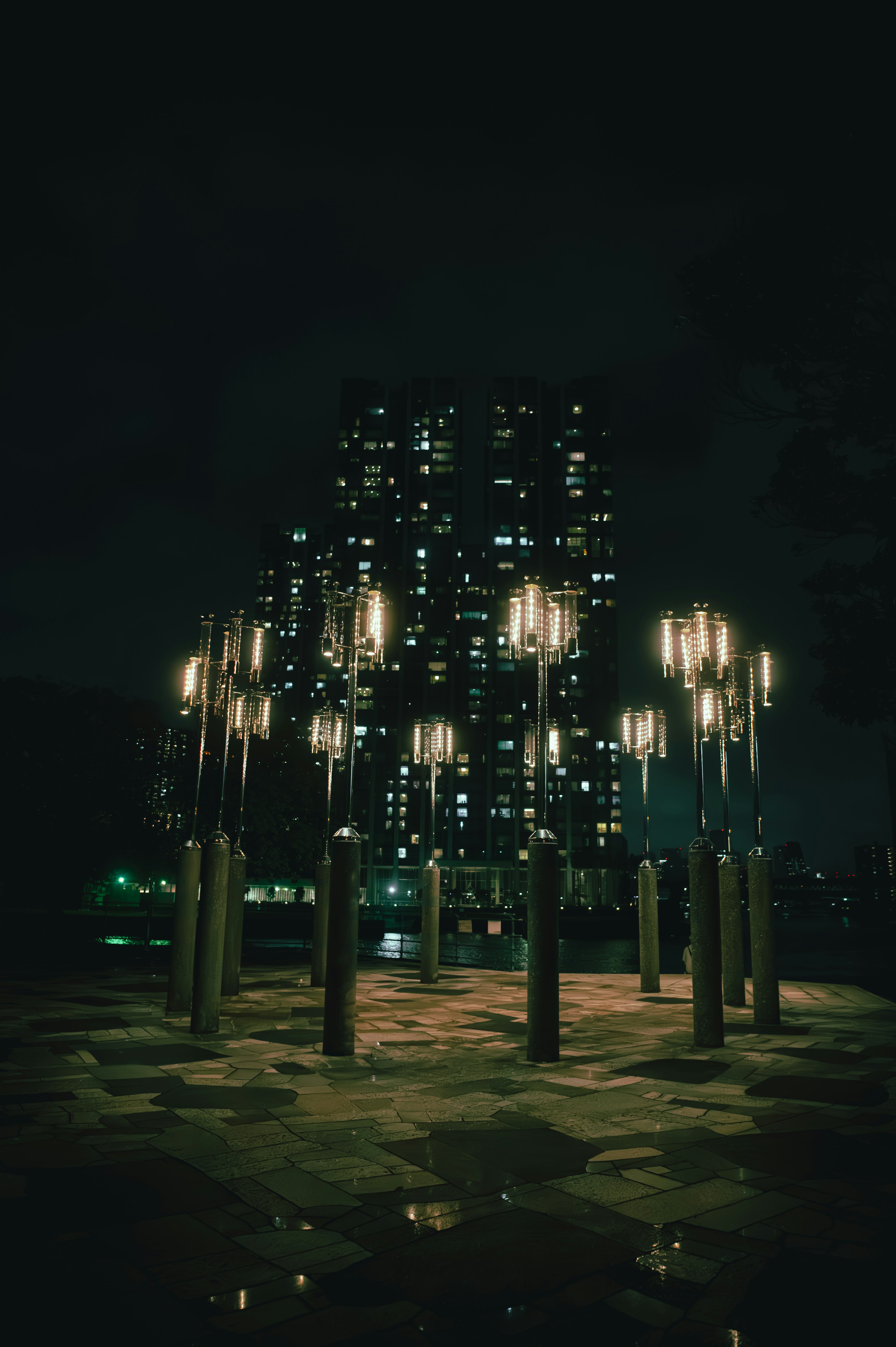 Illuminated installation in a city at night with high-rise buildings in the background