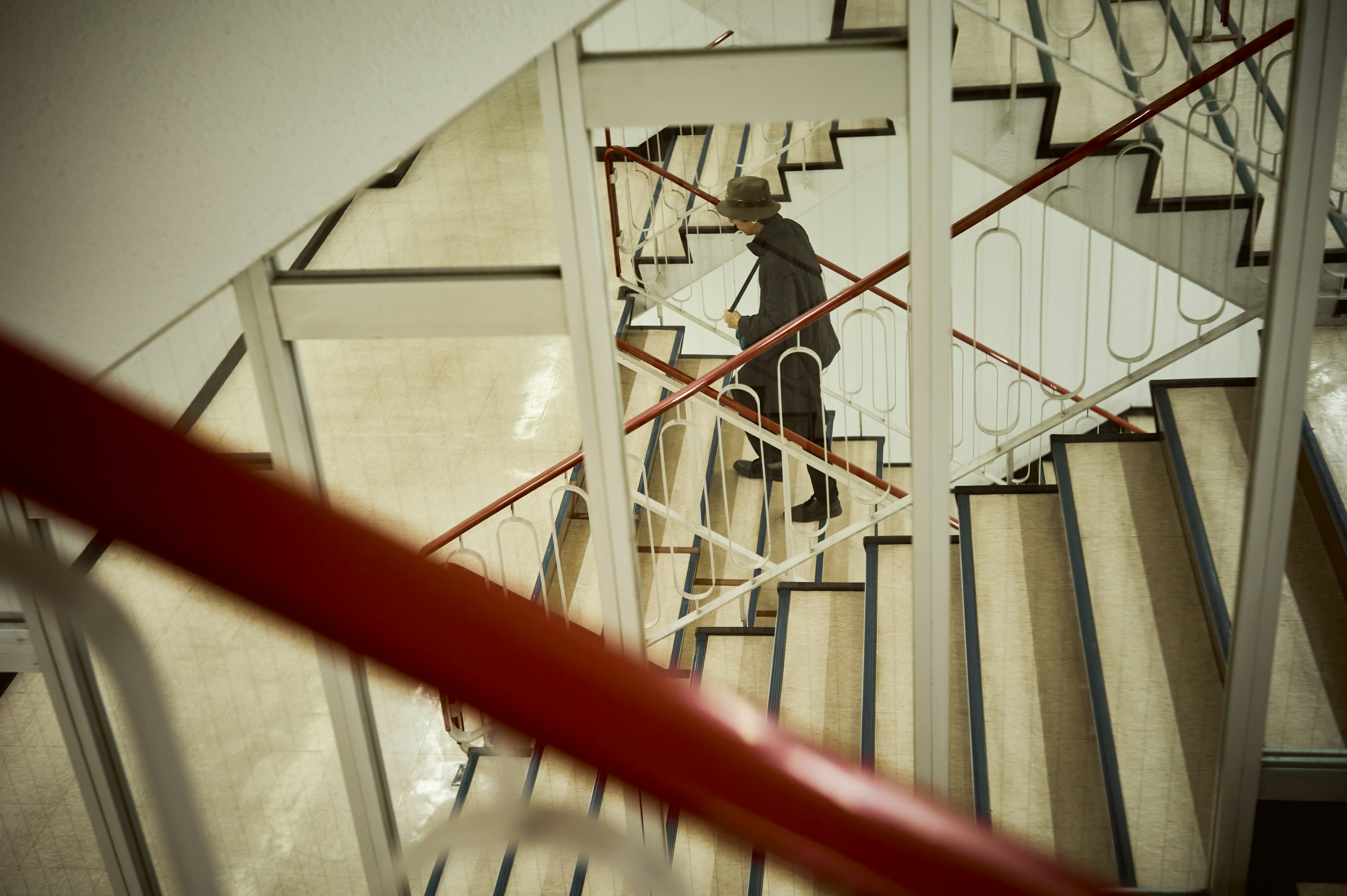 Eine Person, die eine moderne Treppe mit einem weißen Geländer hinuntergeht