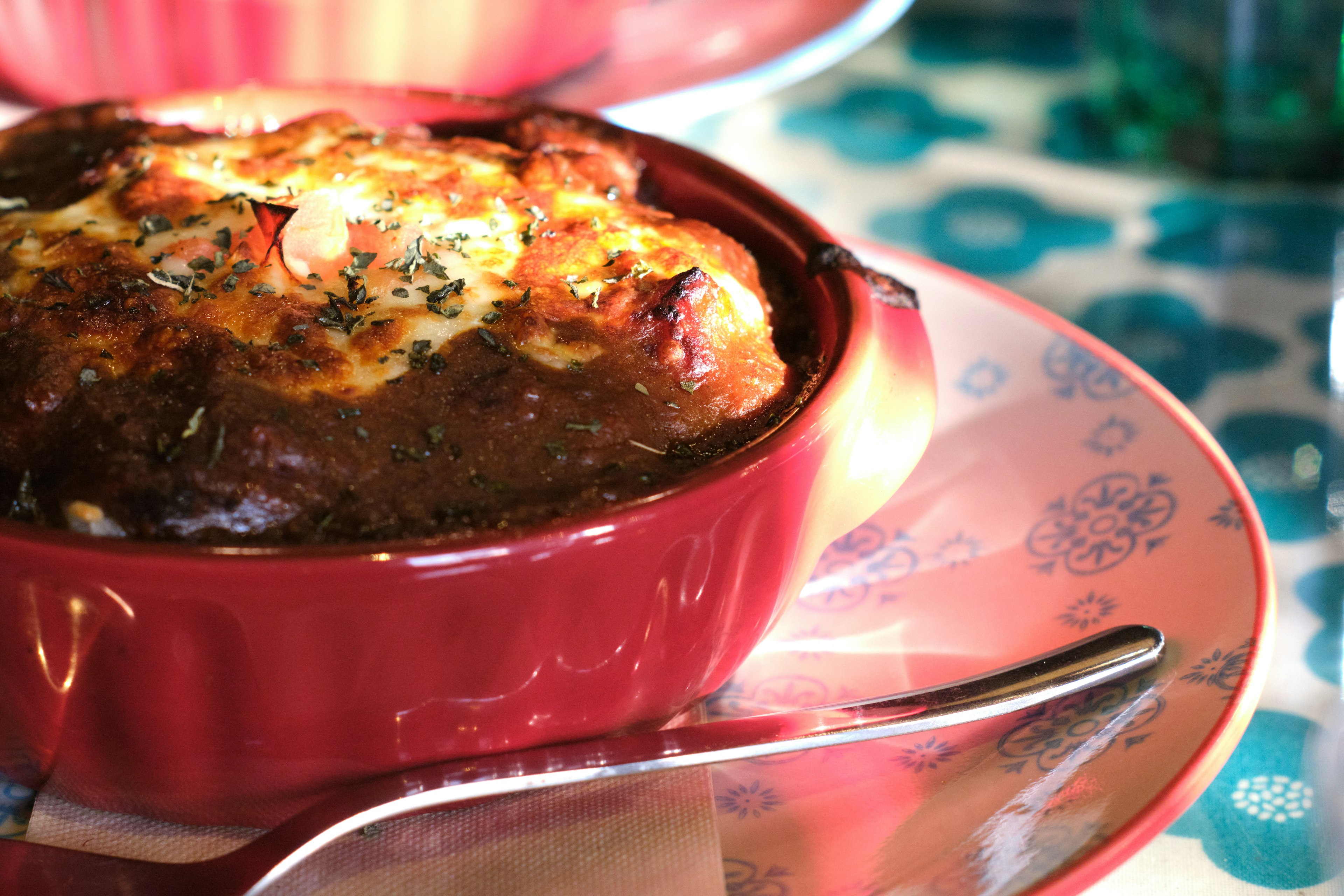 Baked dish in a red ramekin on a decorative plate