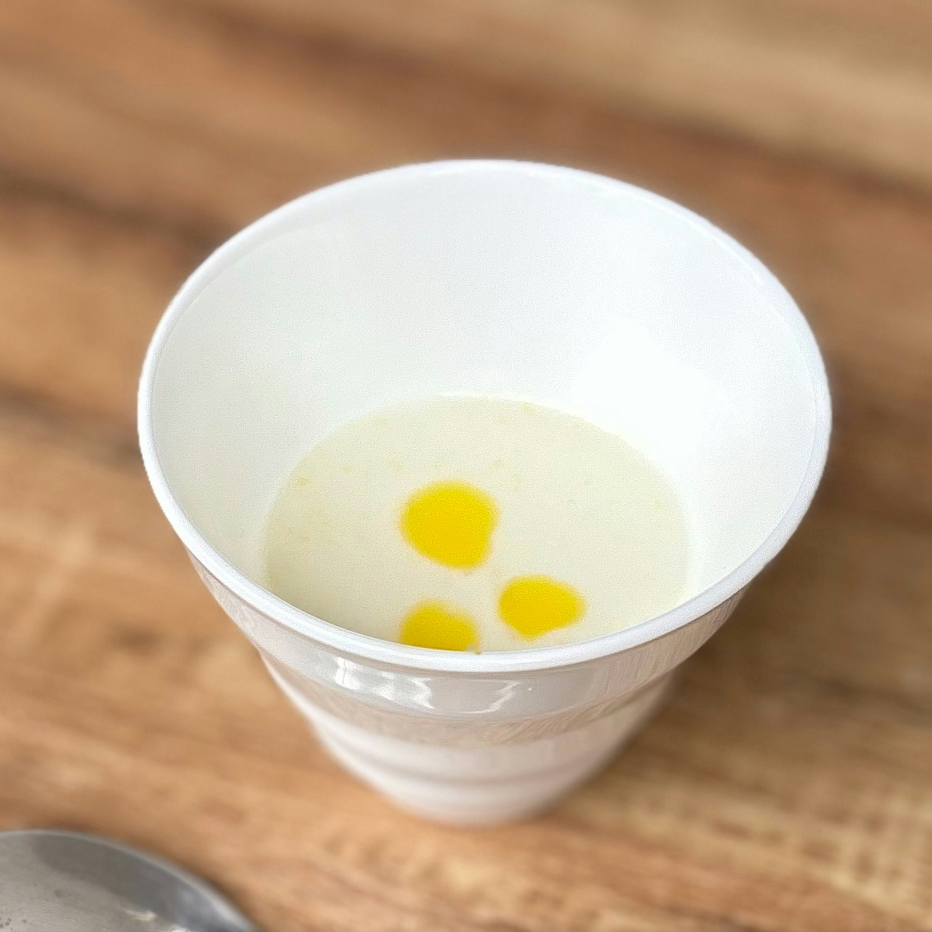 White cup containing creamy substance with egg yolks