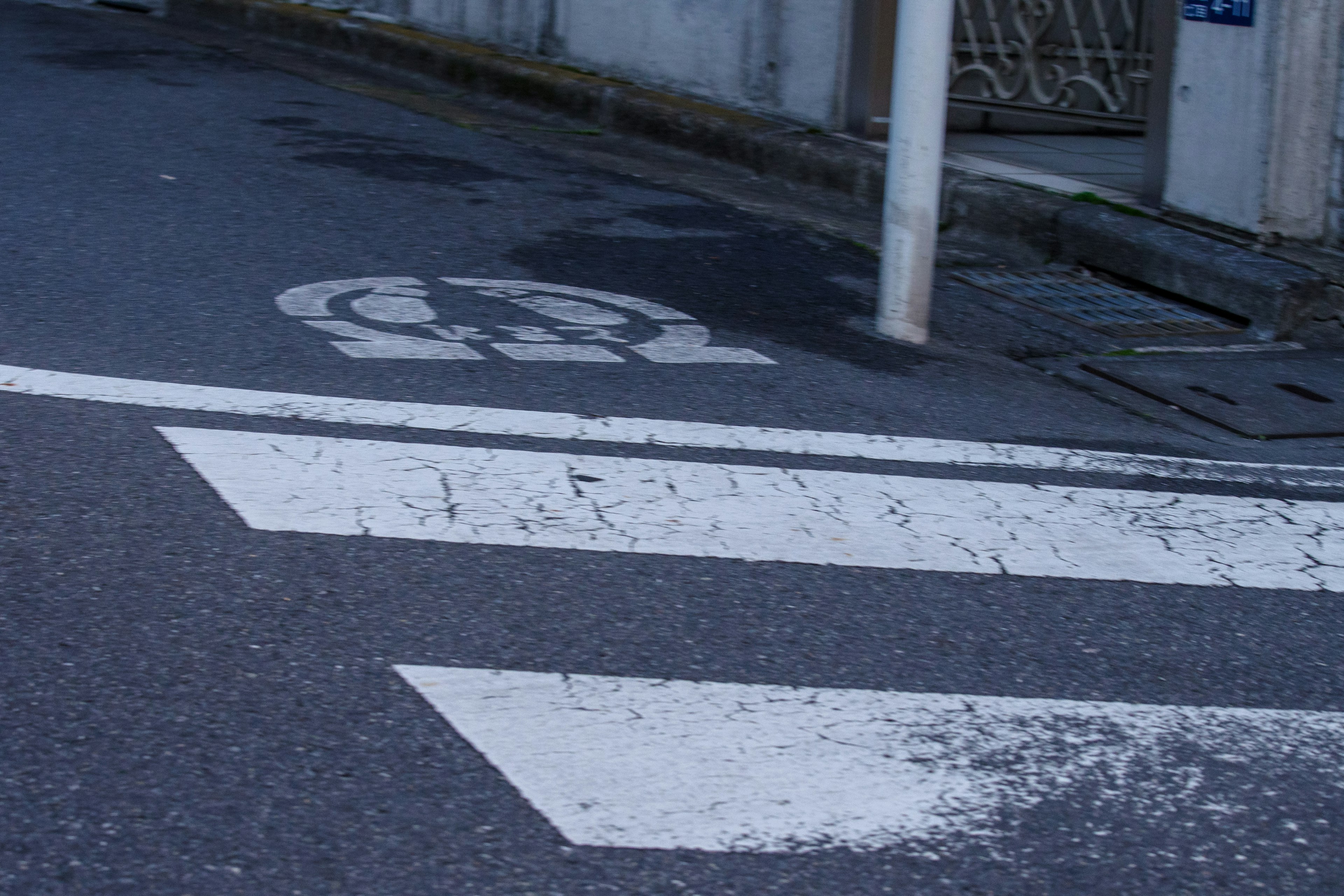 Quiet street corner featuring a crosswalk and vehicle passage mark